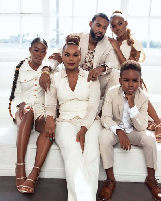 A Family Posing For A Photo In White Clothing Background