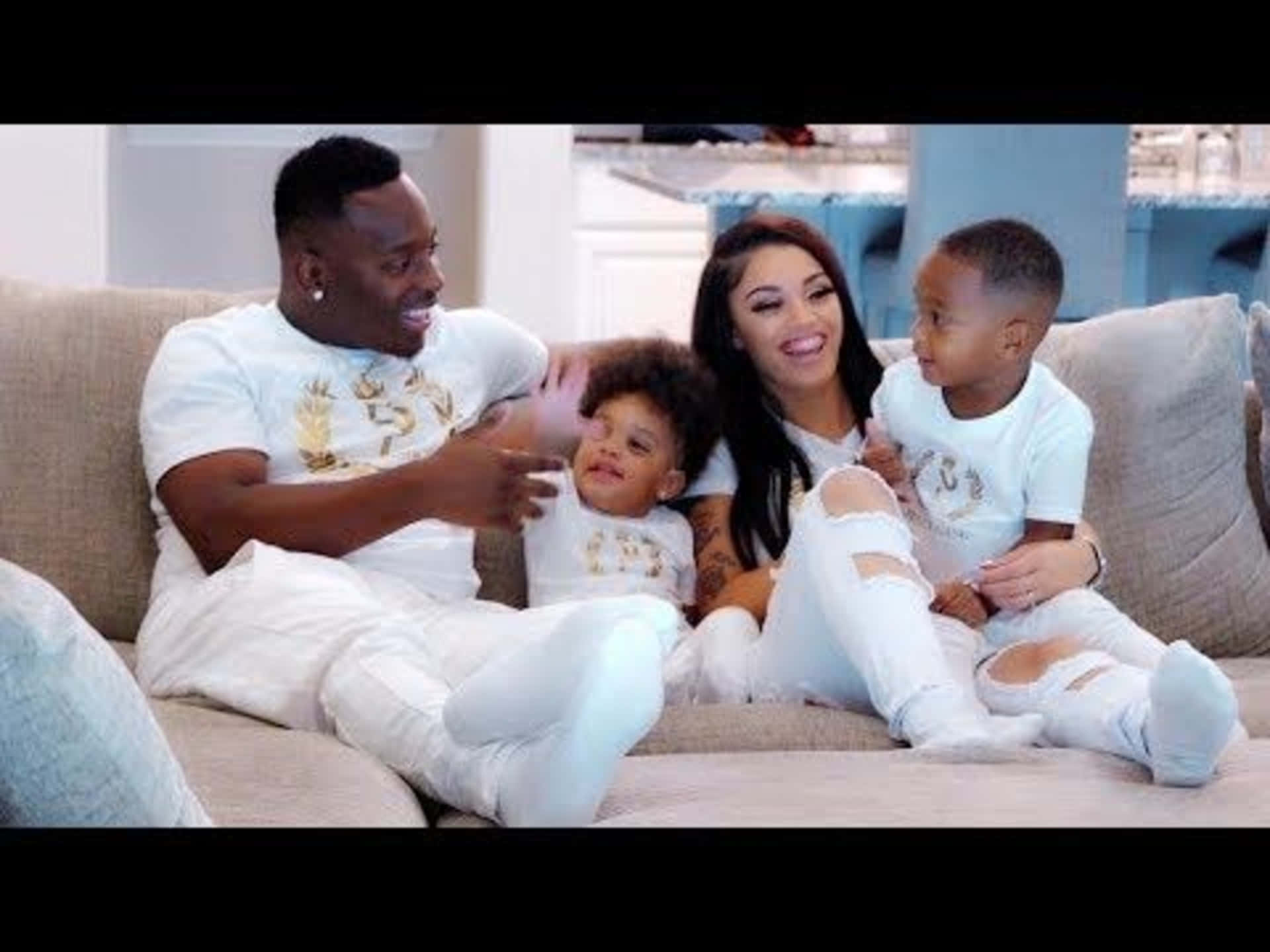 A Family Sitting On A Couch With Two Children