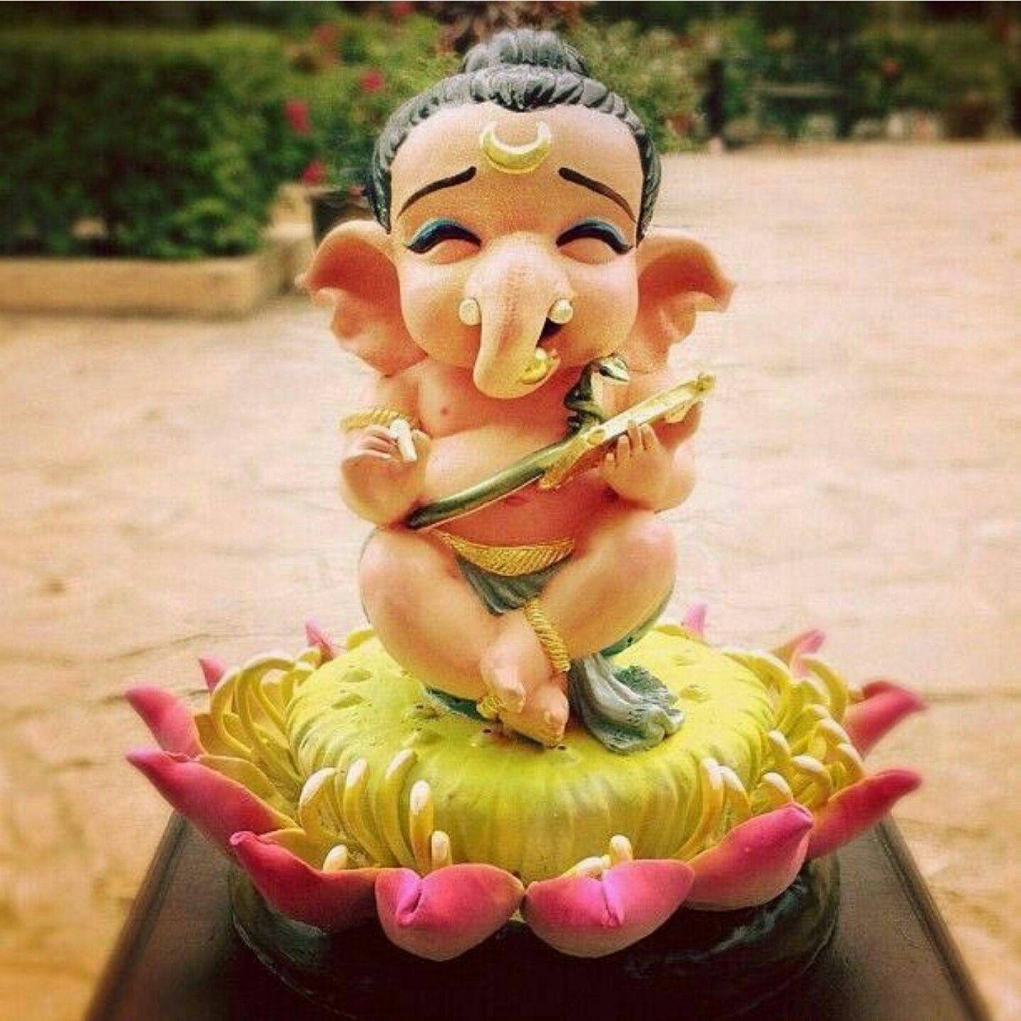 A Fascinating Image Depicts A Baby Statue Of Bal Ganesh Smiling While Sitting On A Lotus Flower Stamen.