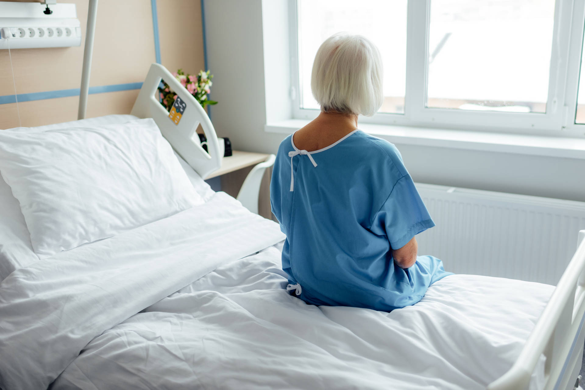 A Female Patient Resting In A Hospital Bed Background