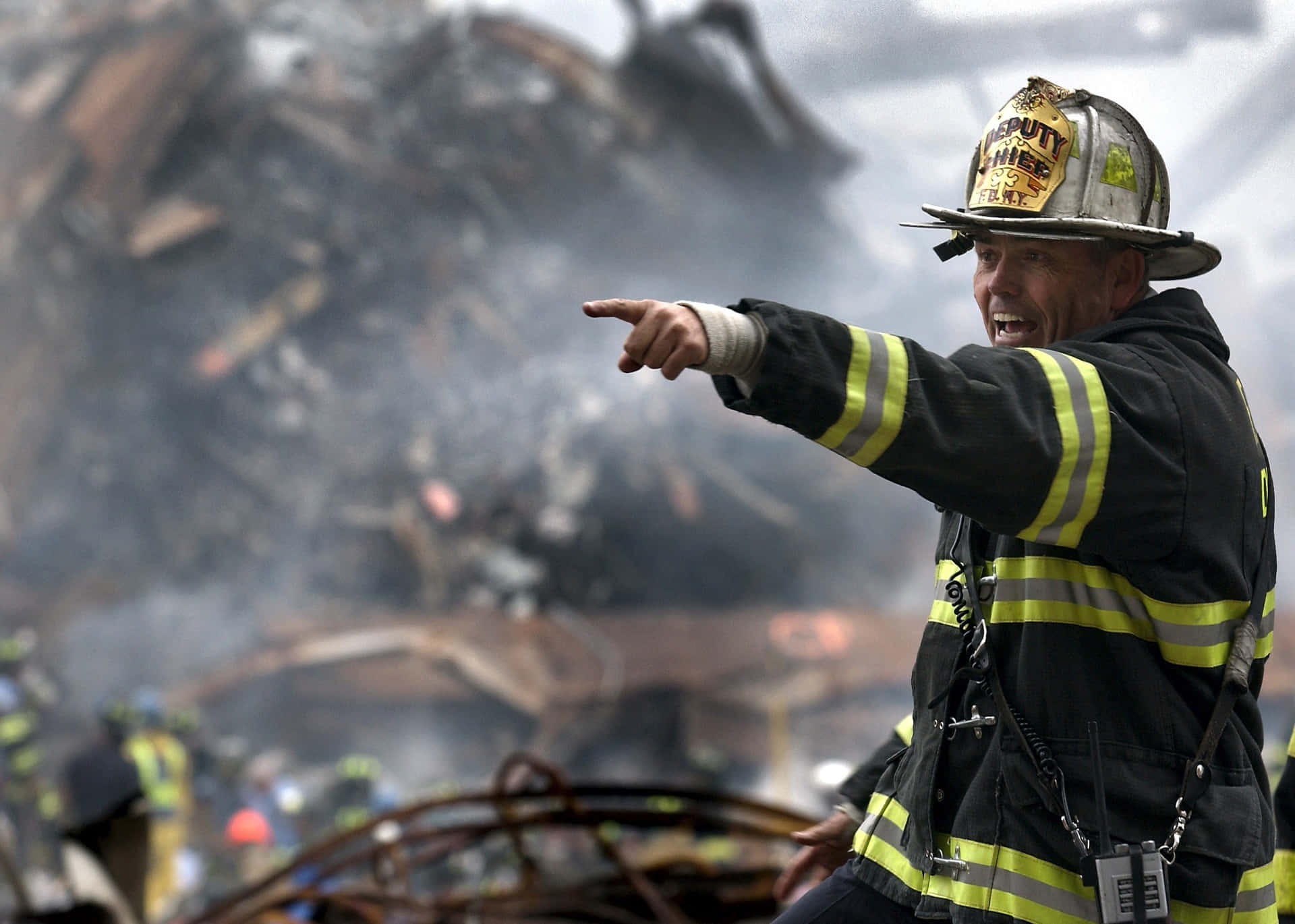 A Firefighter Pointing At A Pile Of Rubble Background