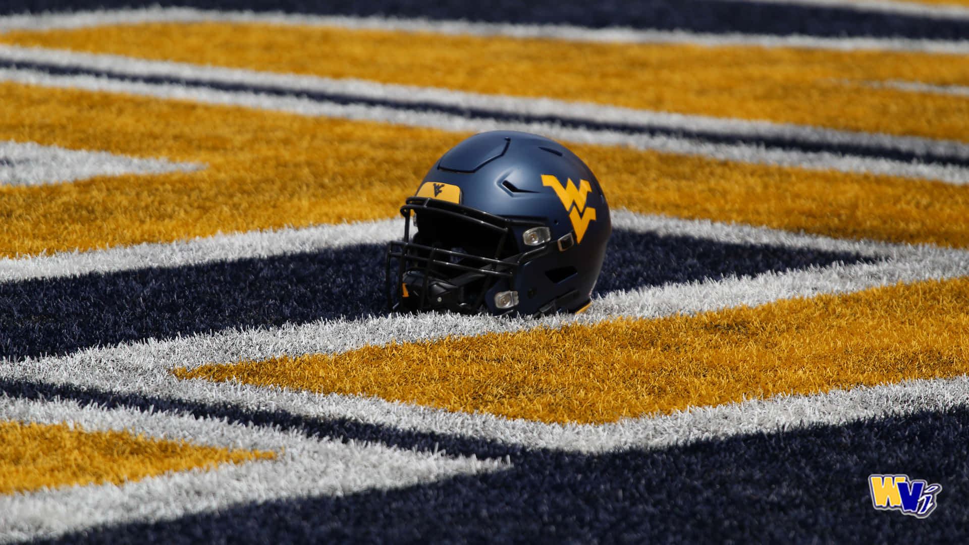 A Football Helmet Is Sitting On The Field Background