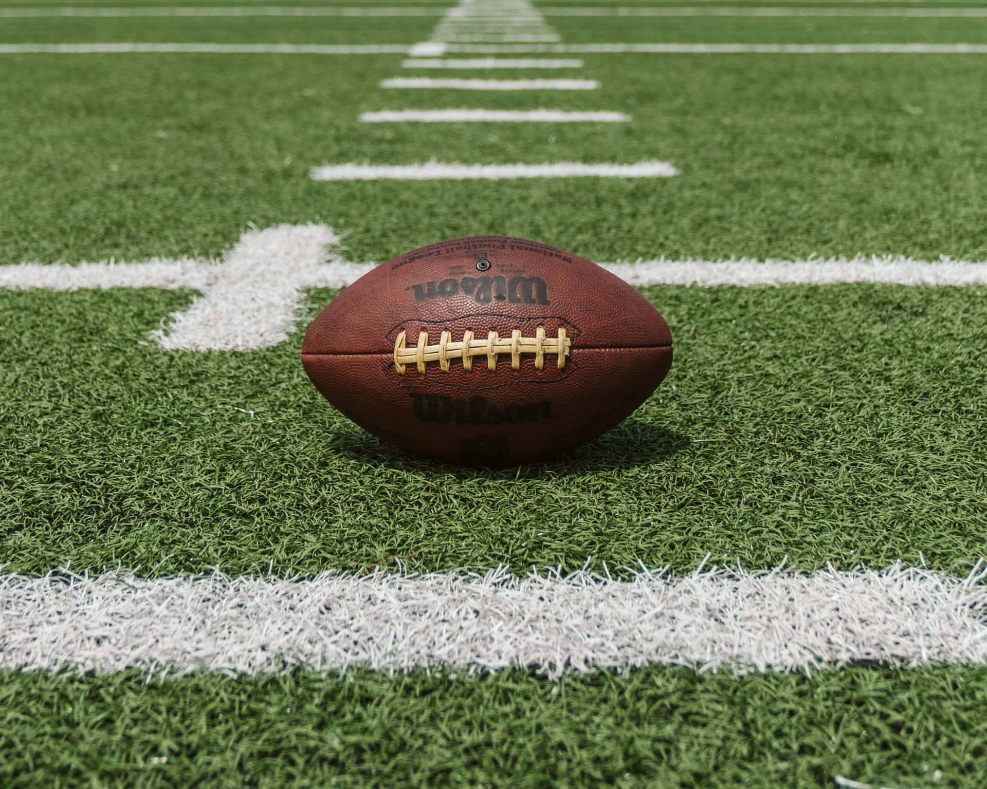 A Football Is Sitting On The Field Background