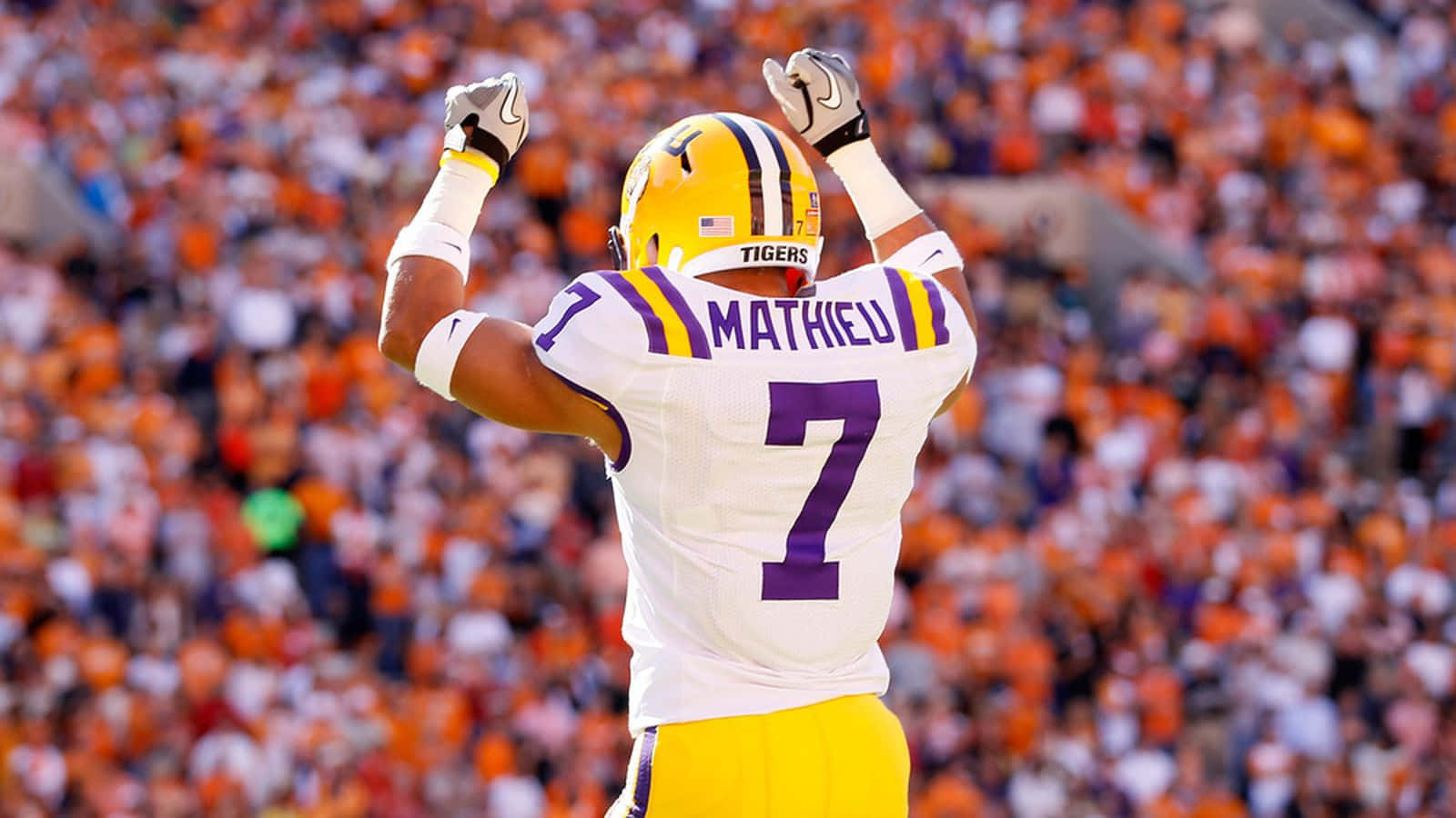 A Football Player Is Celebrating In Front Of An Audience Background