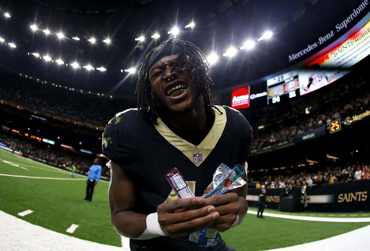 A Football Player Is Holding A Football In His Hands Background