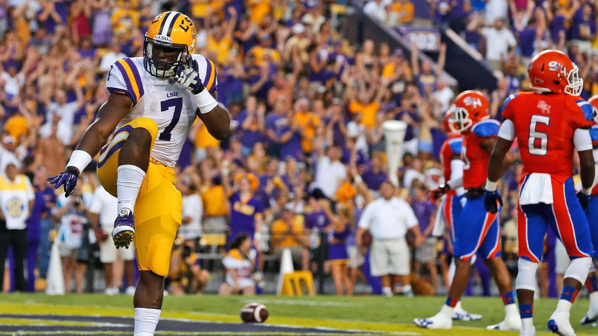 A Football Player Is Running With His Hands Up Background