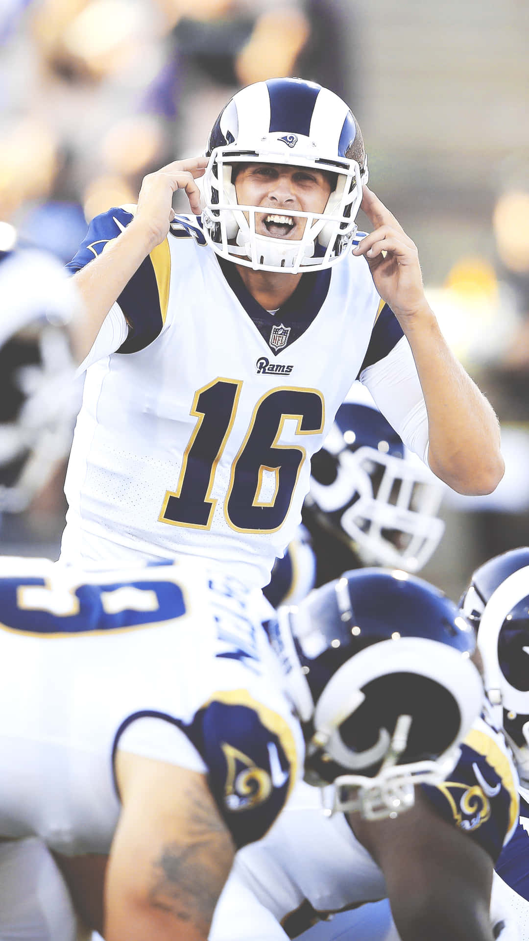 A Football Player Is Throwing A Ball To The Other Players Background