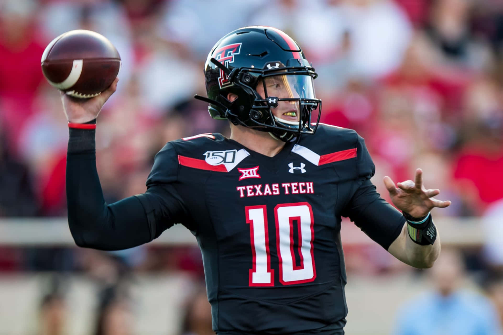 A Football Player Throwing A Ball In A Game Background