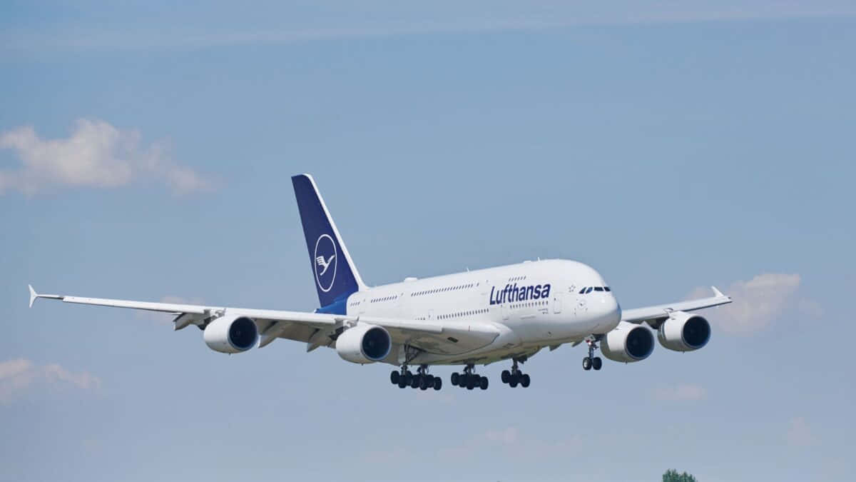 A Giant Commercial Aircraft Flies In The Sky With The Power Of Four Jet Engines. Background