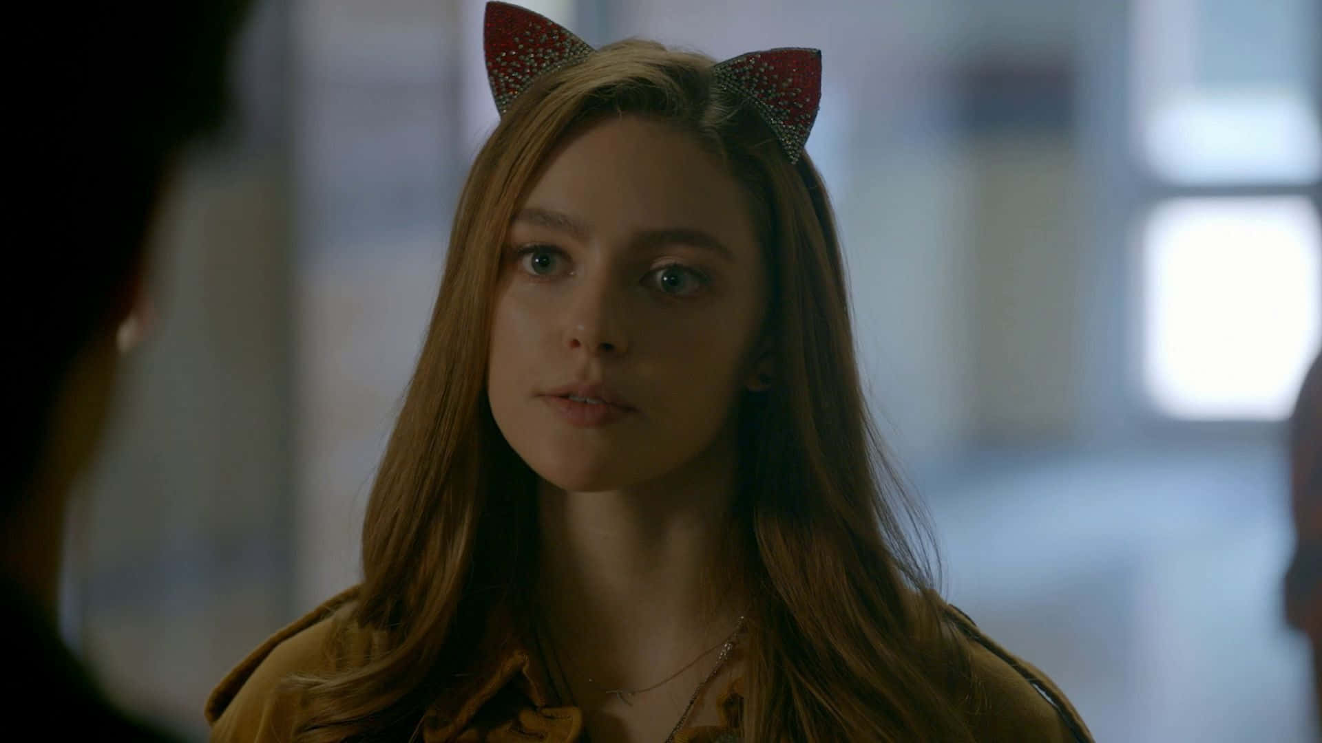 A Girl Wearing Cat Ears Is Looking At Someone Background