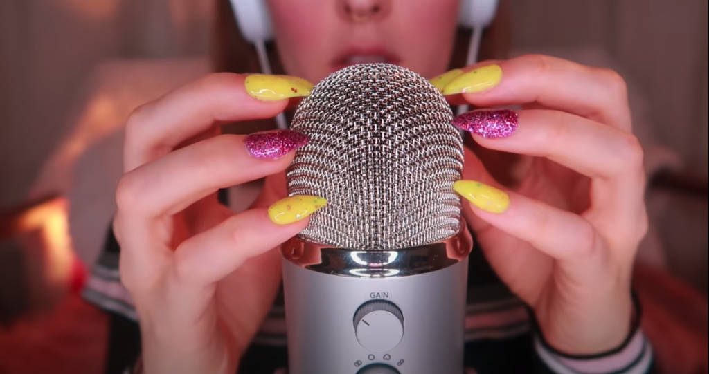A Girl With A Microphone Holding Her Nails Background