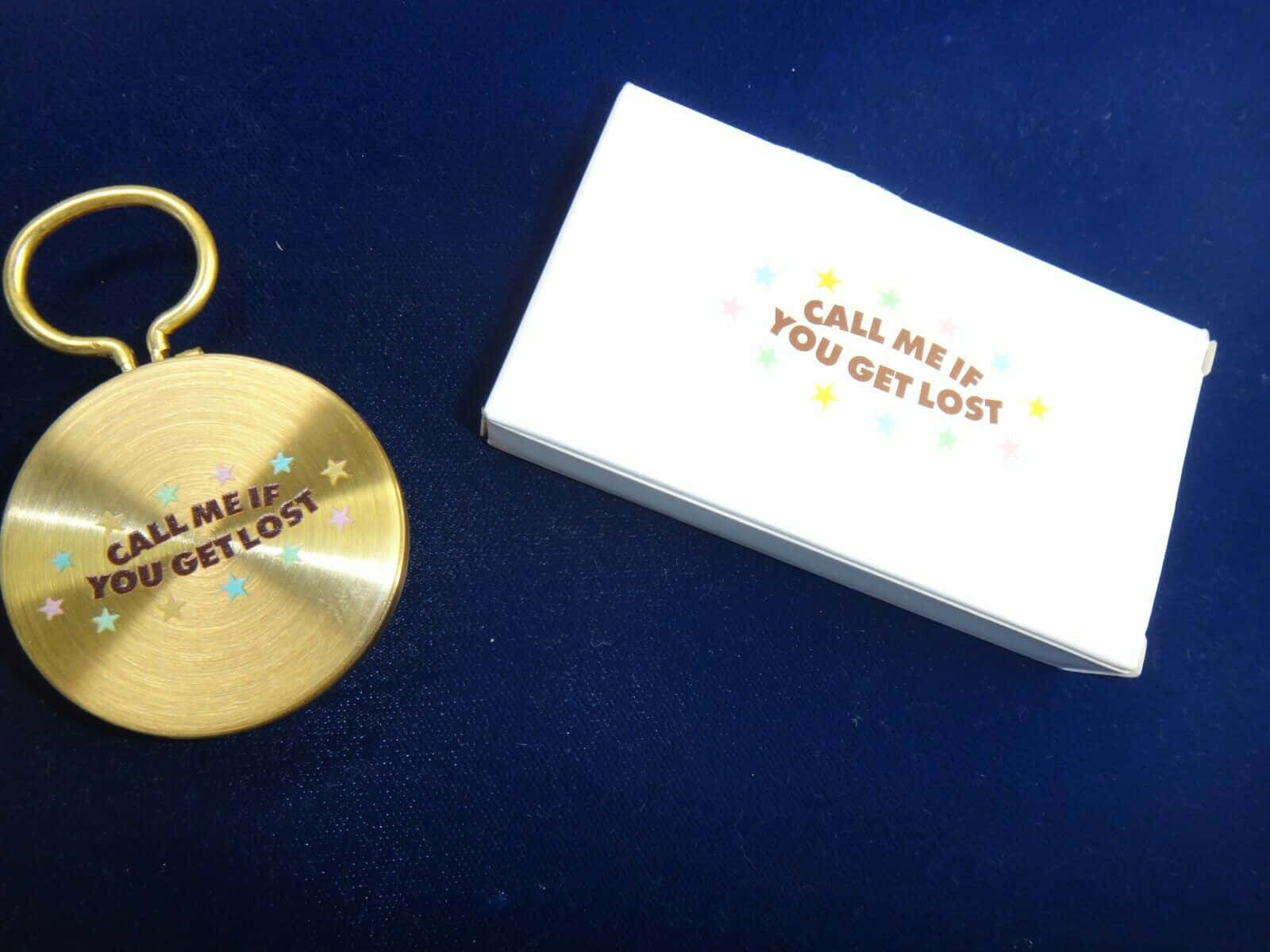 A Gold Key Chain With A Business Card On It Background