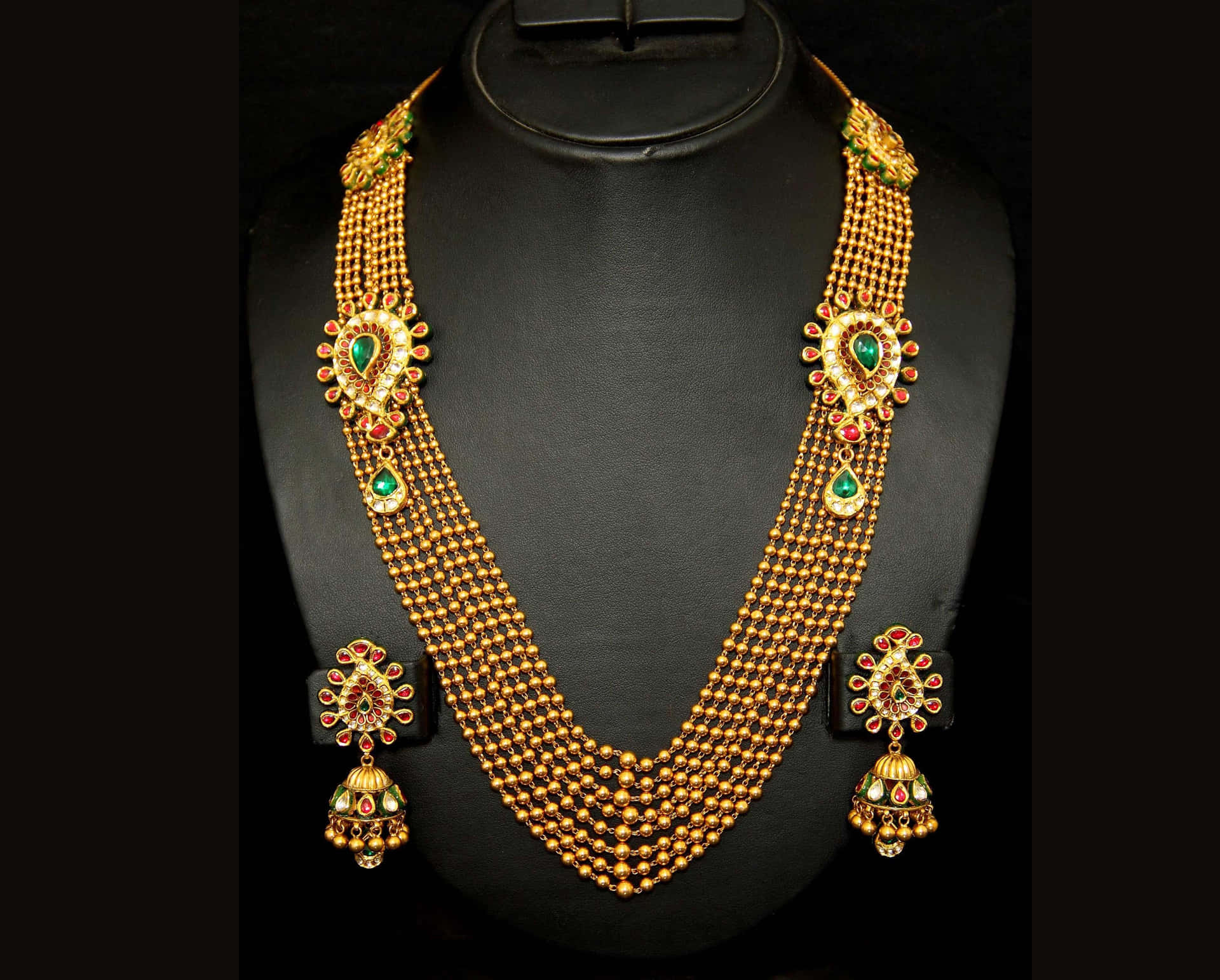 A Gold Necklace Set With Emeralds And Emeralds Background
