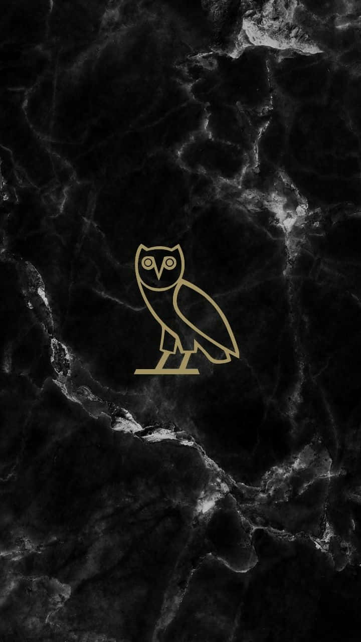 A Gold Owl Logo On A Black Marble Background Background