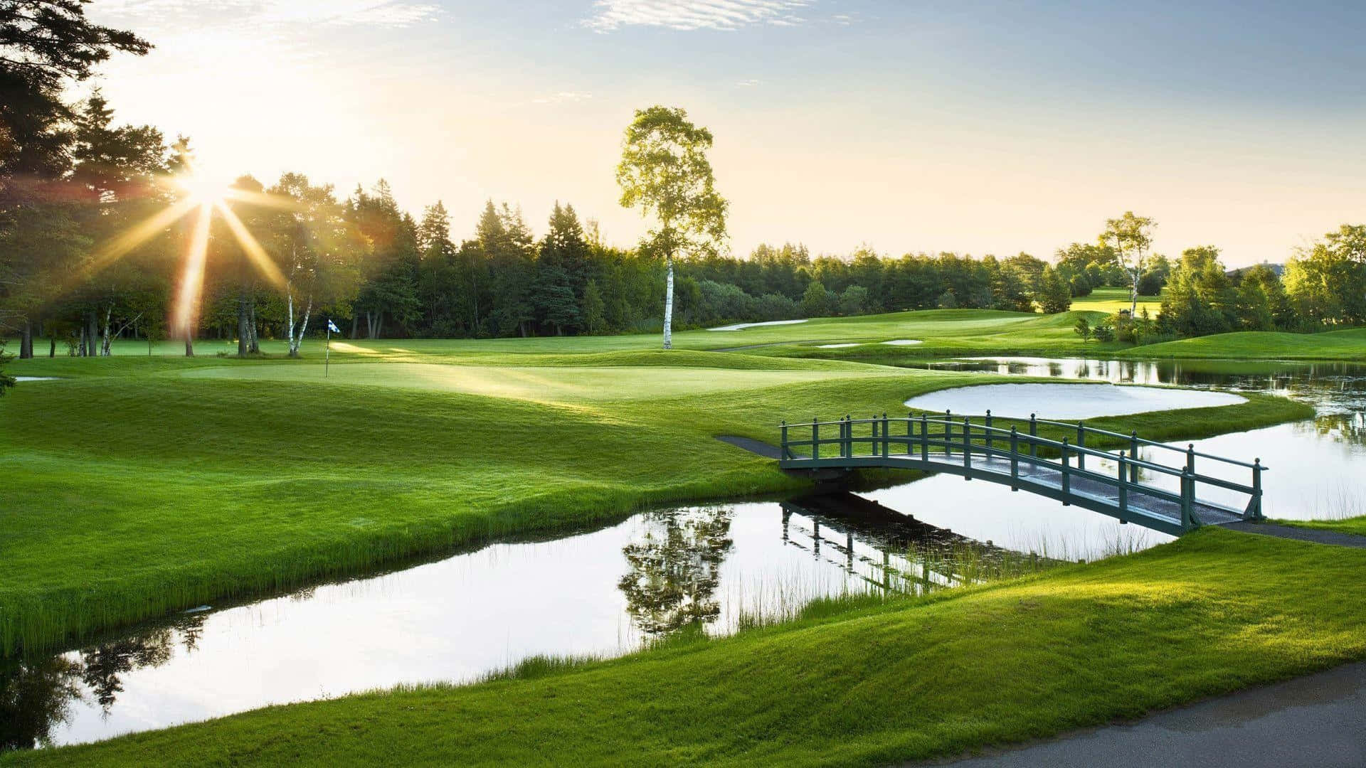 A Golf Course With A Bridge And Water Background