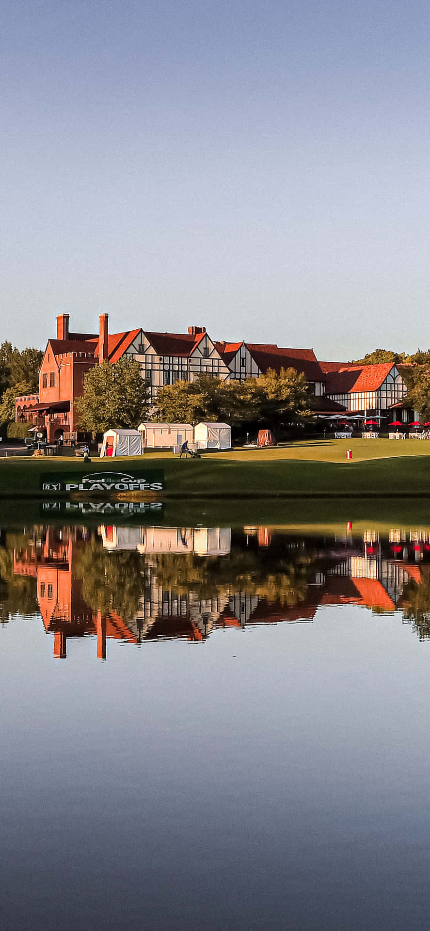 A Golf Course With A House Reflected In The Water Background