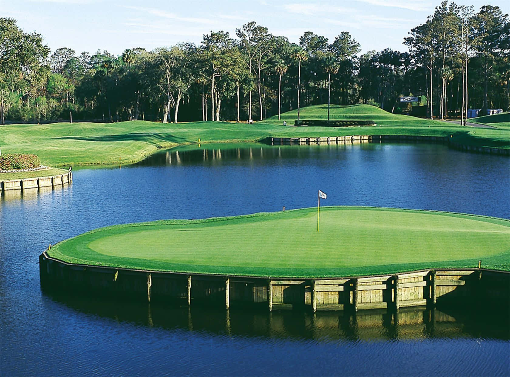 A Golf Course With A Lake And A Green Background