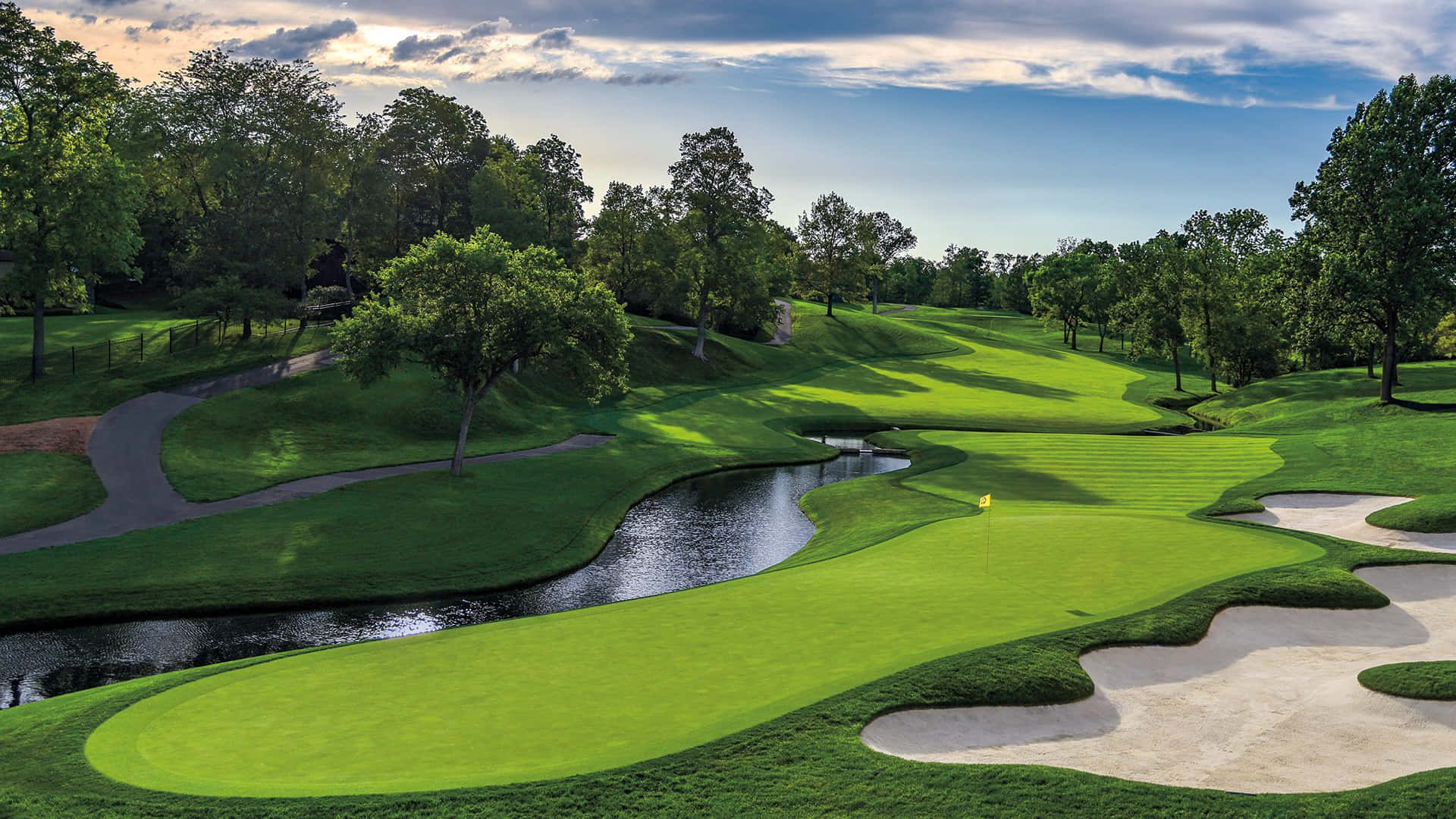 A Golf Course With A Stream And Trees