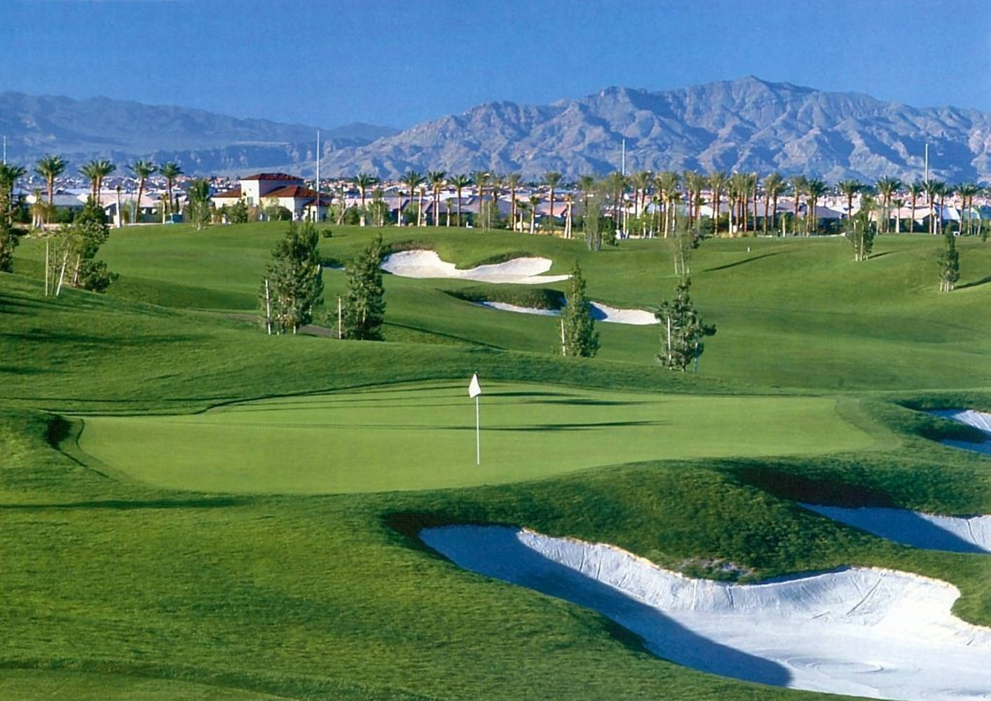 A Golf Course With Mountains In The Background Background