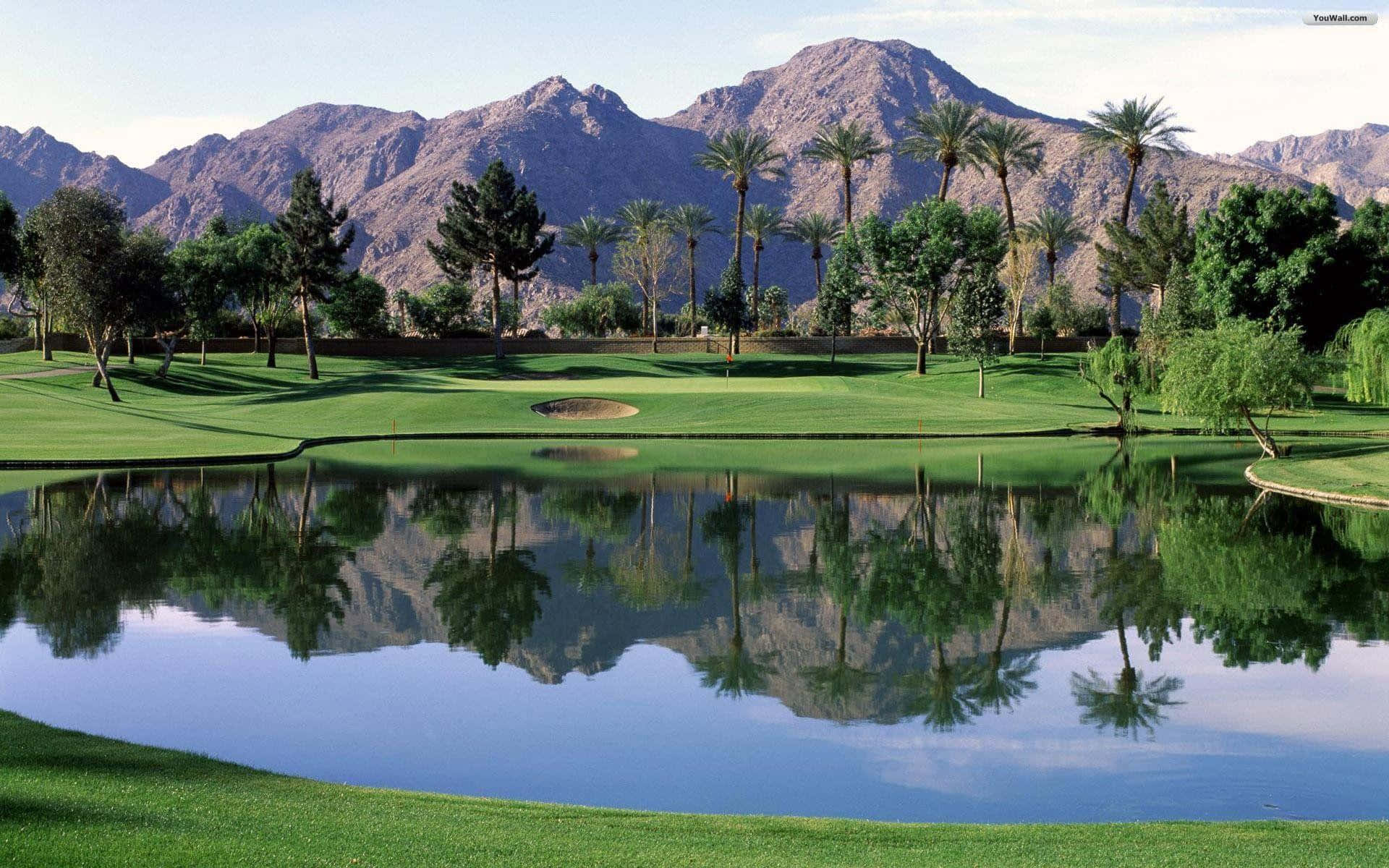 A Golf Course With Mountains In The Background Background