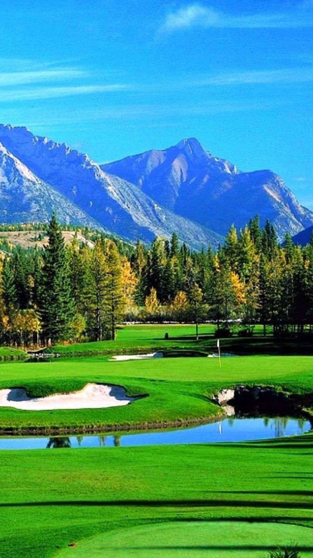 A Golf Course With Mountains In The Background Background