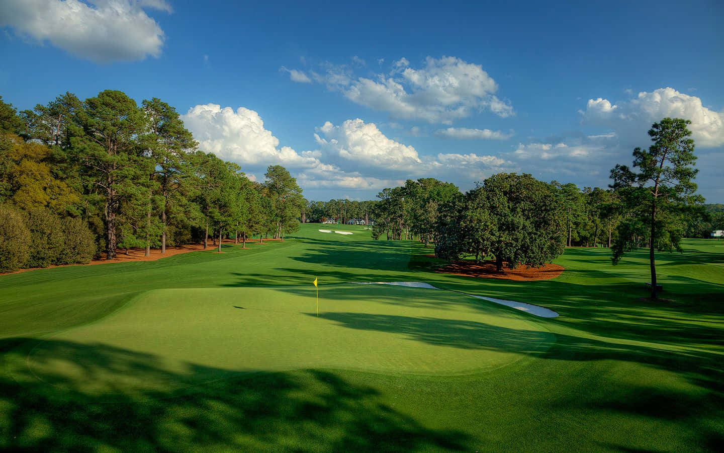 A Golf Course With Trees And Green Grass