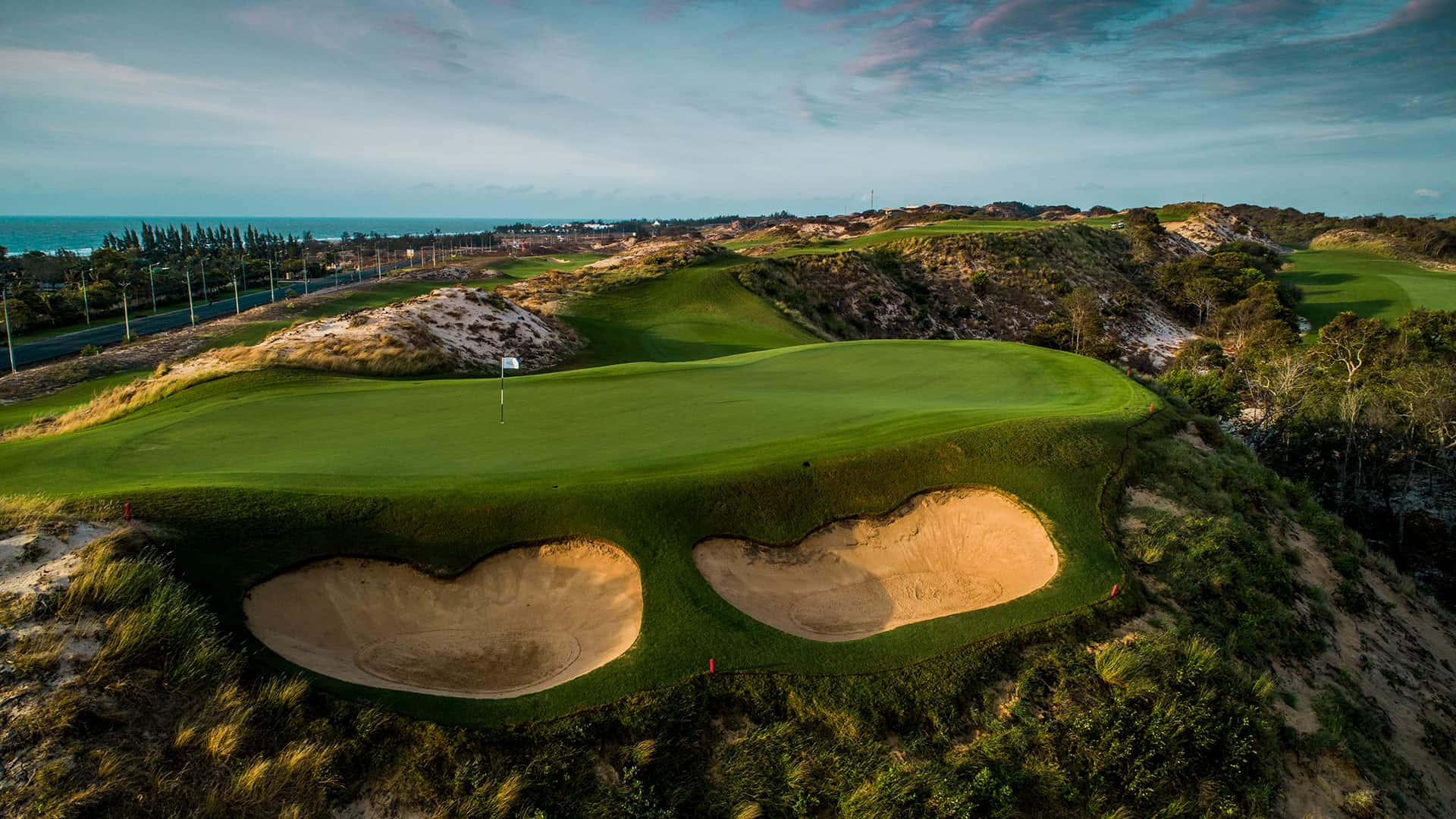 A Golf Course With Two Holes In The Sand Background