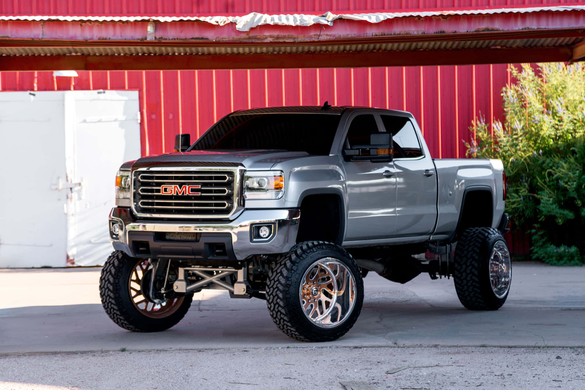 A Gray Truck Parked In Front Of A Red Barn Background