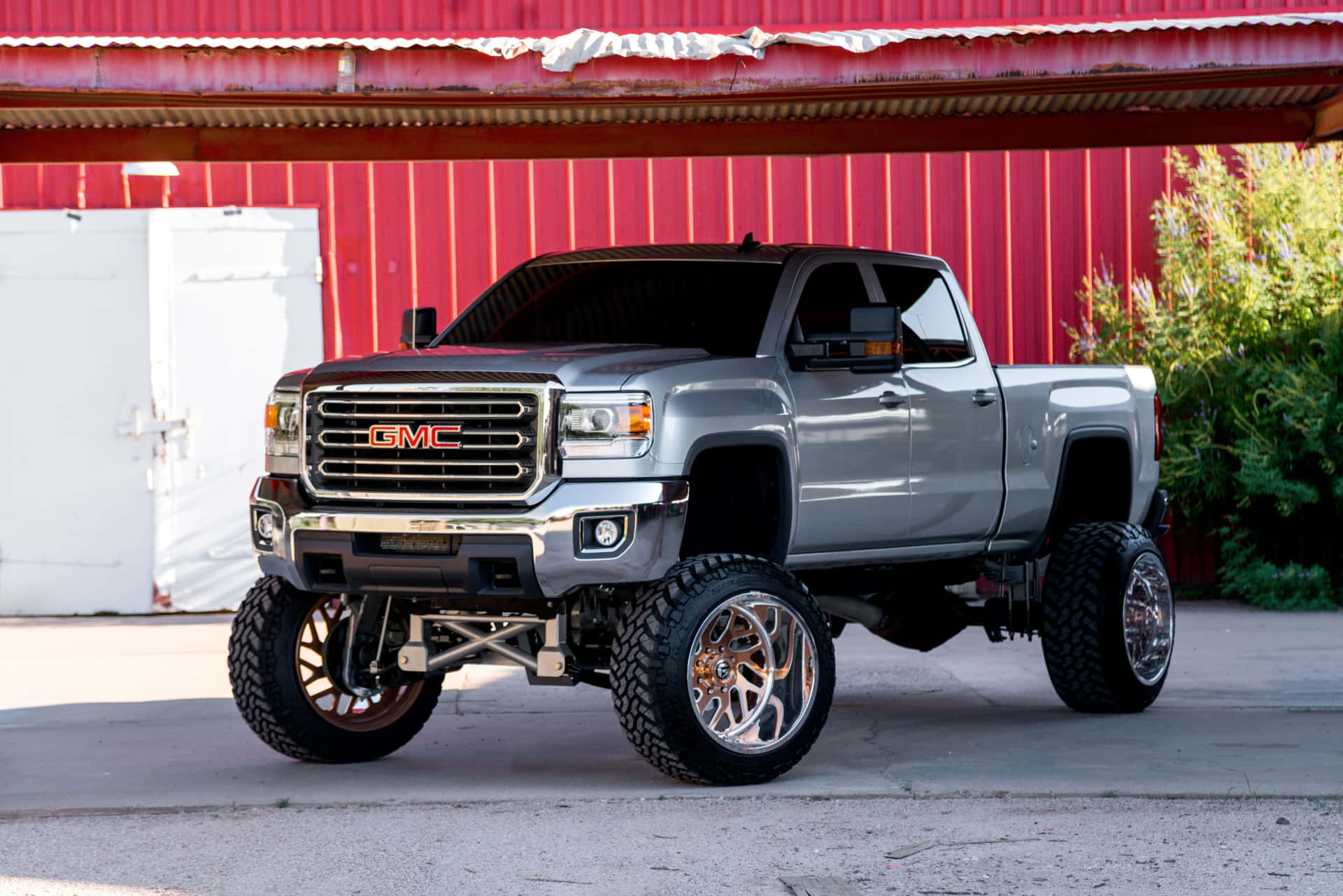 A Gray Truck Parked In Front Of A Red Barn