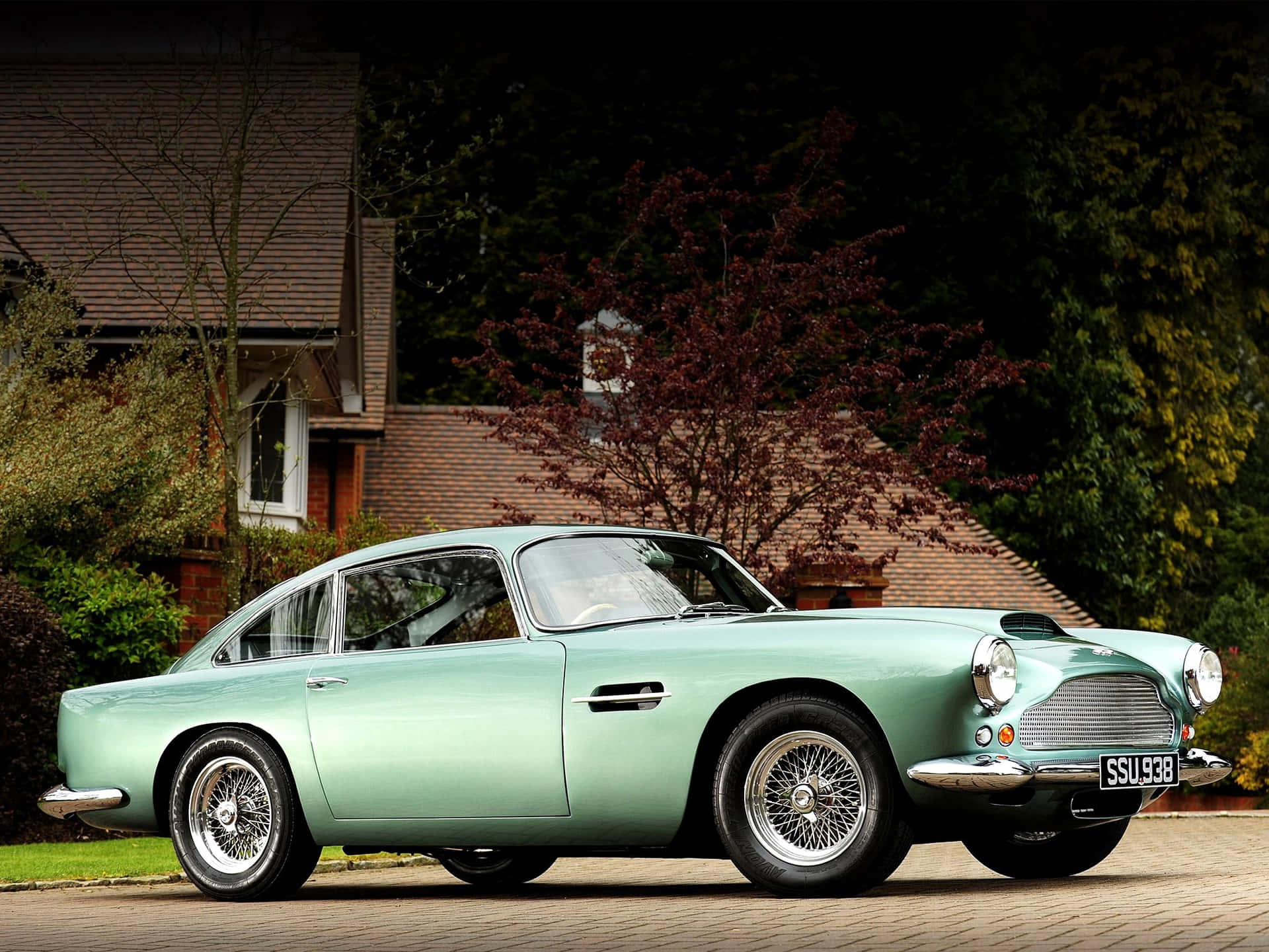 A Green Aston Martin Db5 Parked In Front Of A House