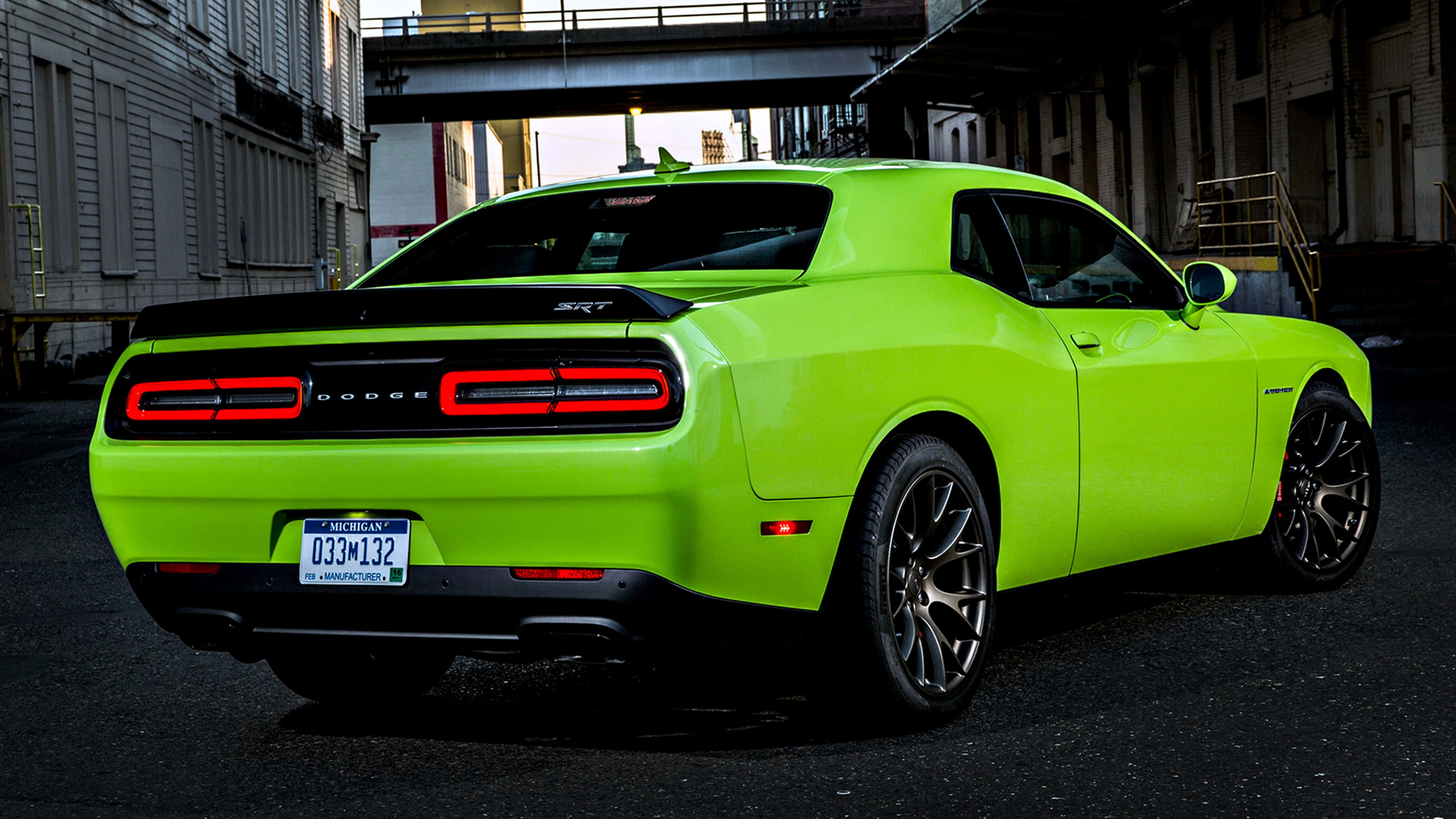 A Green Dodge Challenger Parked On A Street Background
