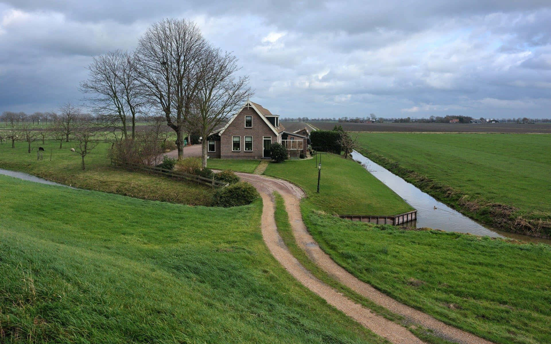 A Green Field With A House Background