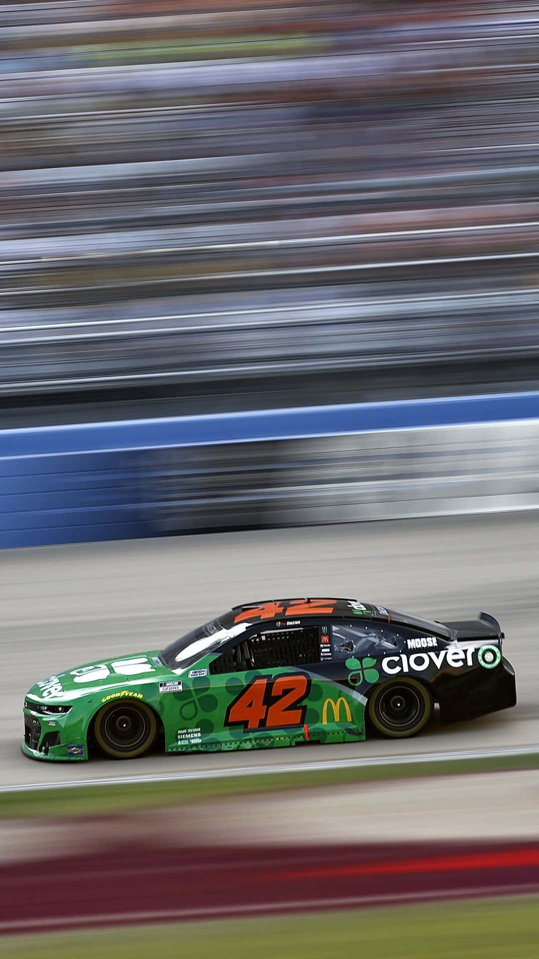 A Green Nascar Car Is Driving On A Track