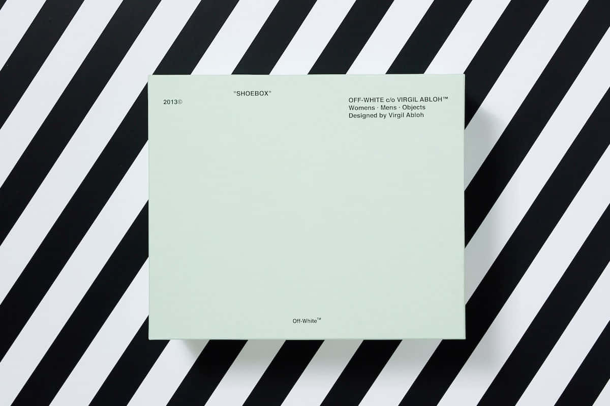 A Green Notebook On A Black And White Striped Background Background