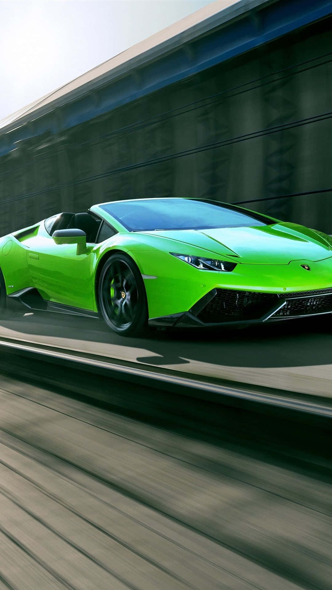 A Green Sports Car Is Driving Down A Track Background