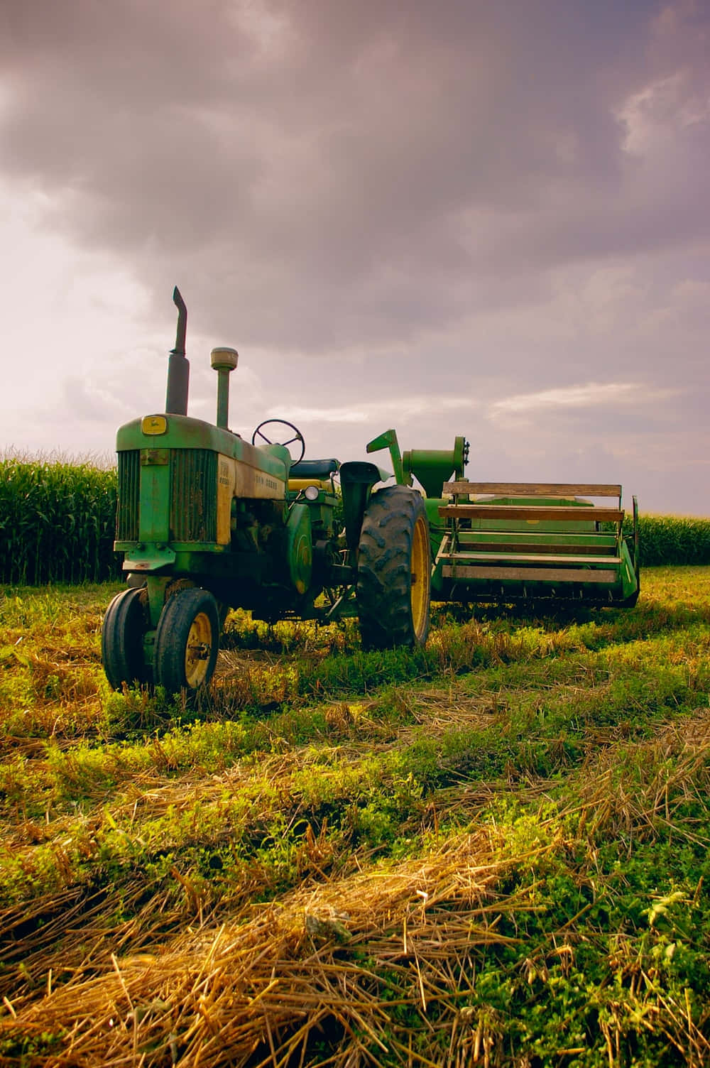 A Green Tractor In A Field Background