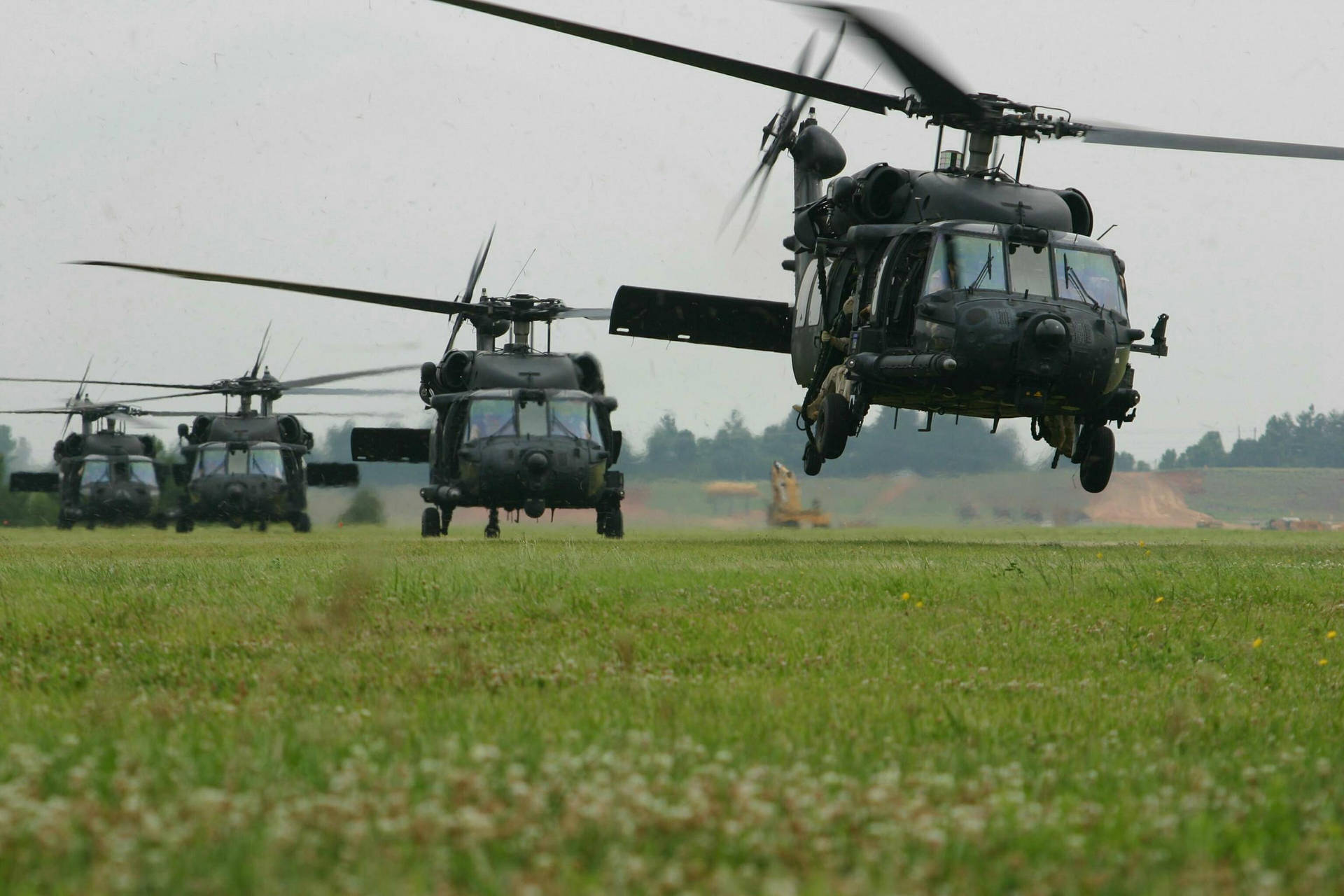 A Group Of Black Helicopters Flying In Formation Background