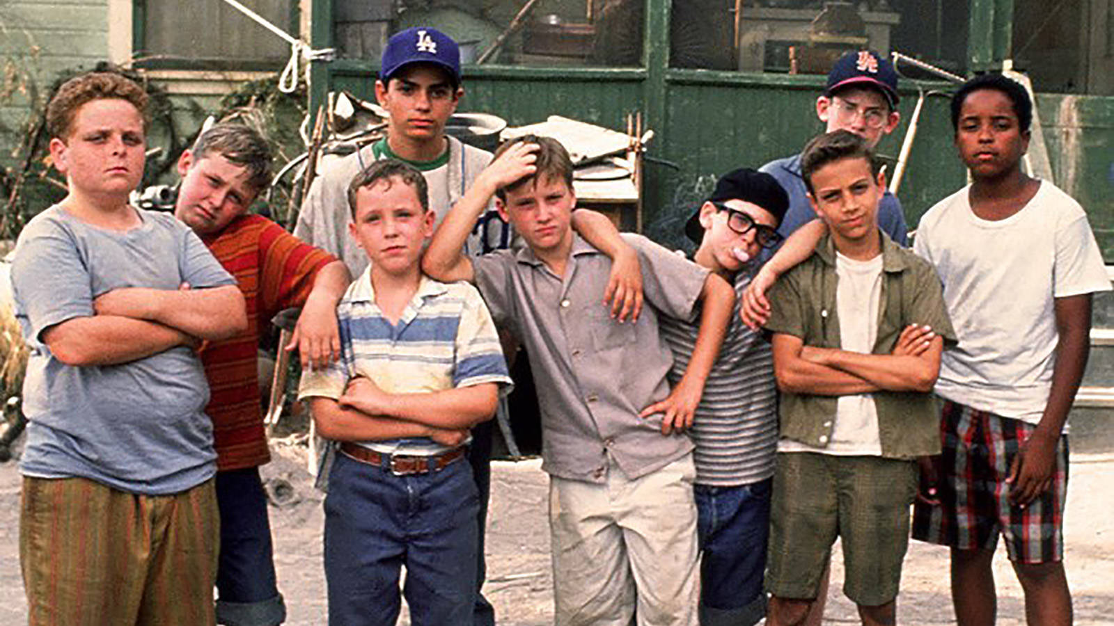 A Group Of Boys Standing In Front Of A Building Background