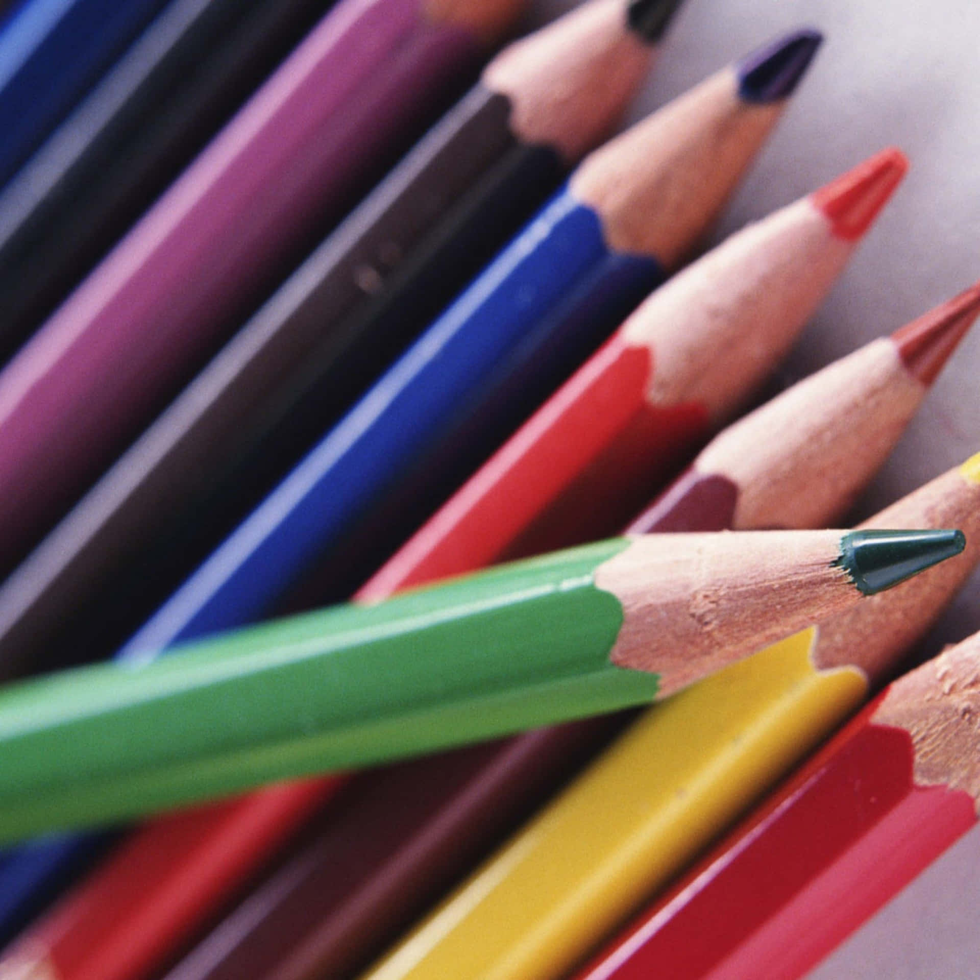 A Group Of Colored Pencils Are Arranged In A Row Background
