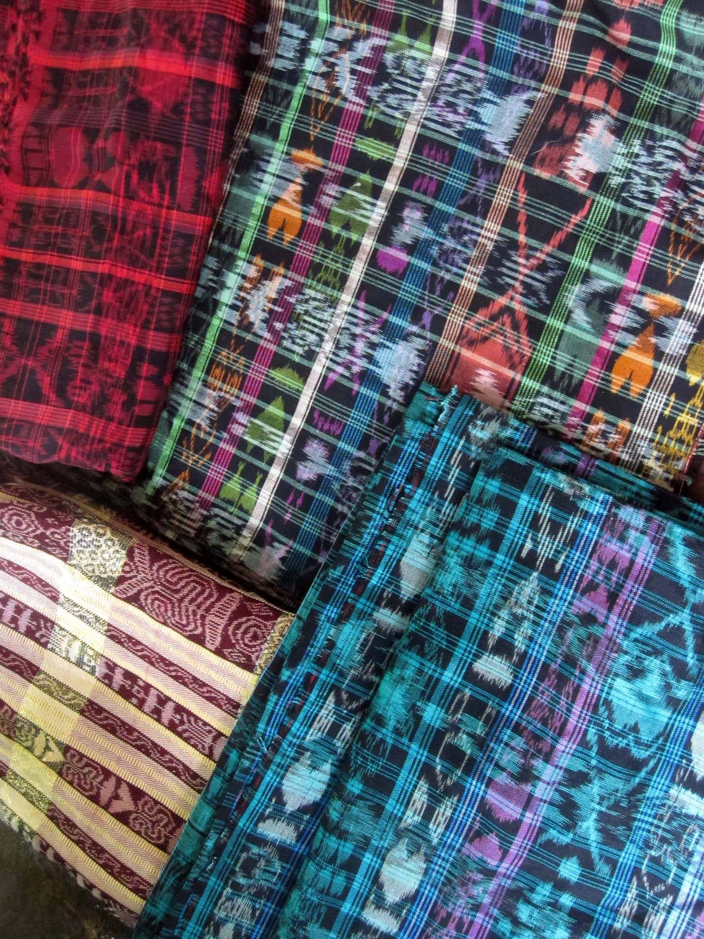 A Group Of Colorful Patterned Bags Are Stacked On Top Of Each Other Background