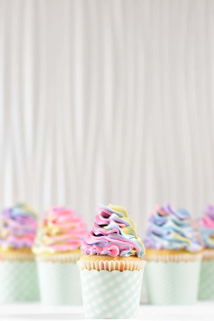 A Group Of Cupcakes With Colorful Frosting Background