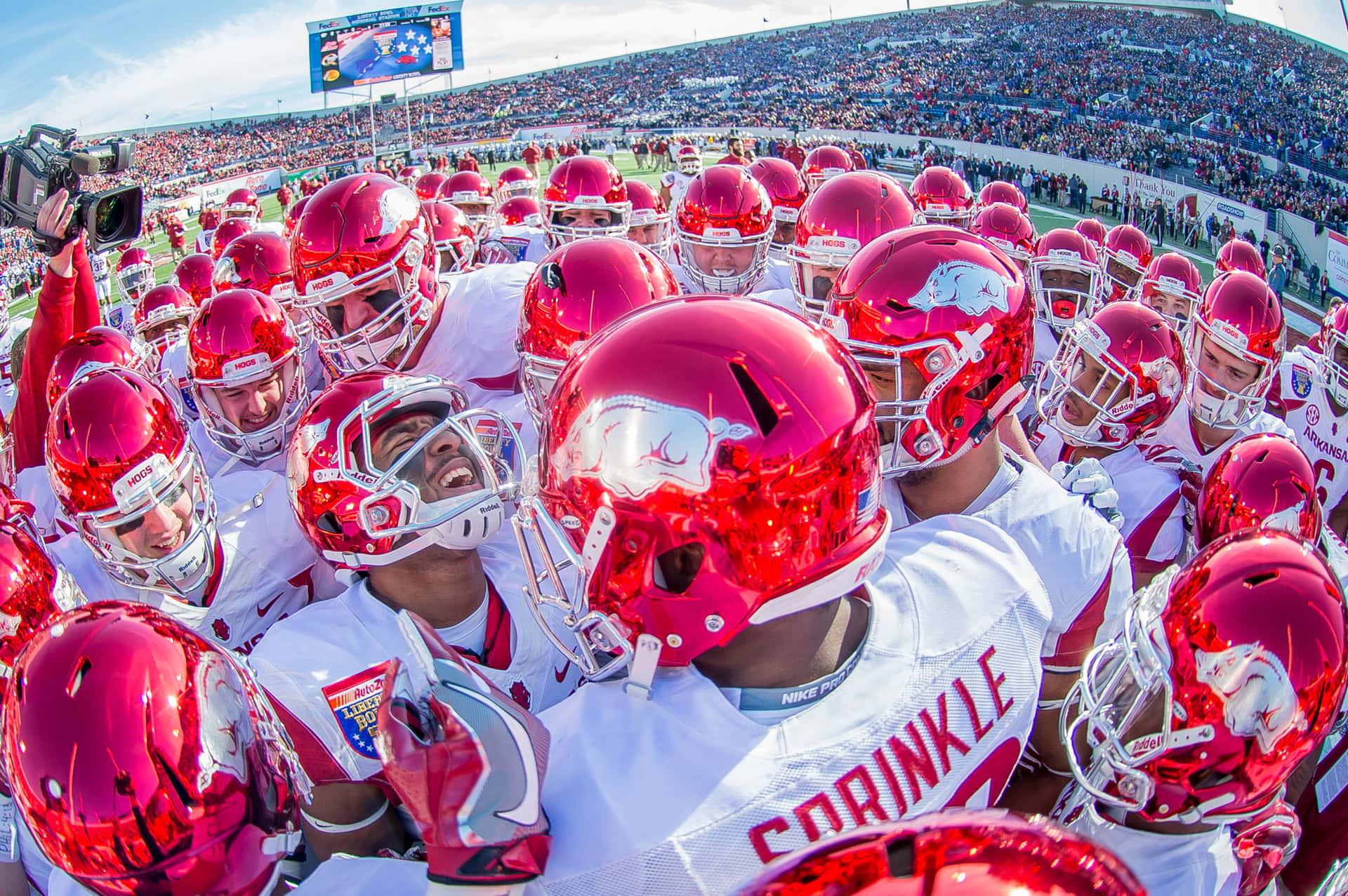 A Group Of Football Players Huddle Together Background