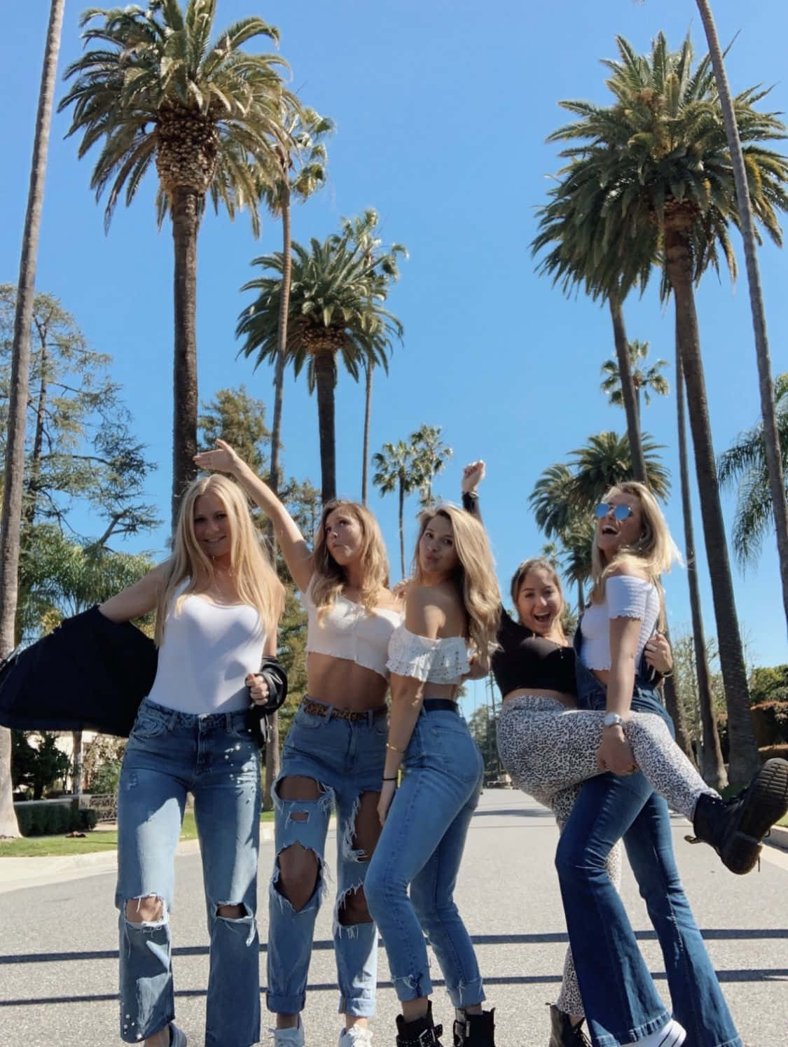 A Group Of Girls In Jeans And T-shirts Posing For A Photo Background