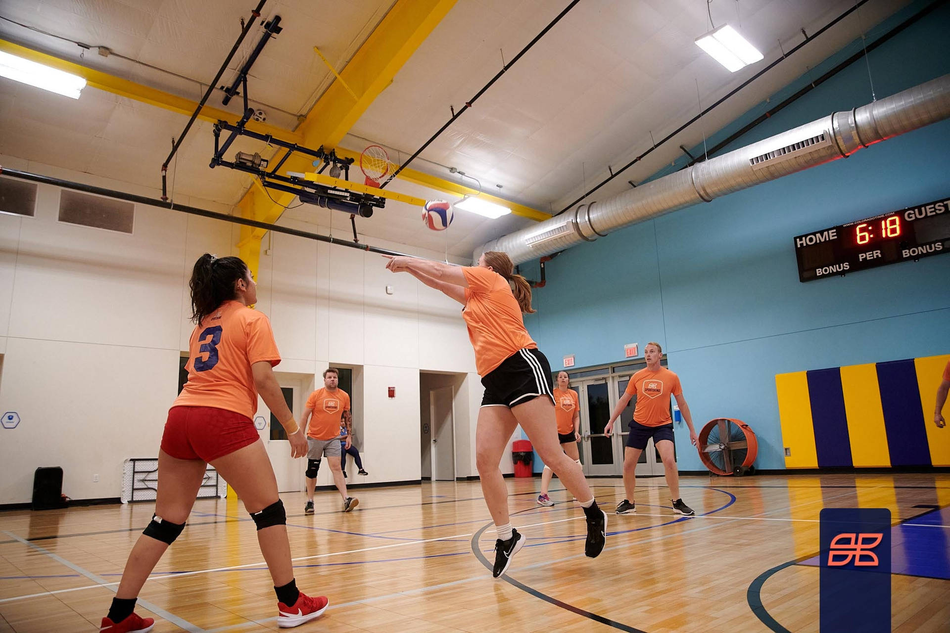 A Group Of Girls Playing Volleyball In A Gym Background