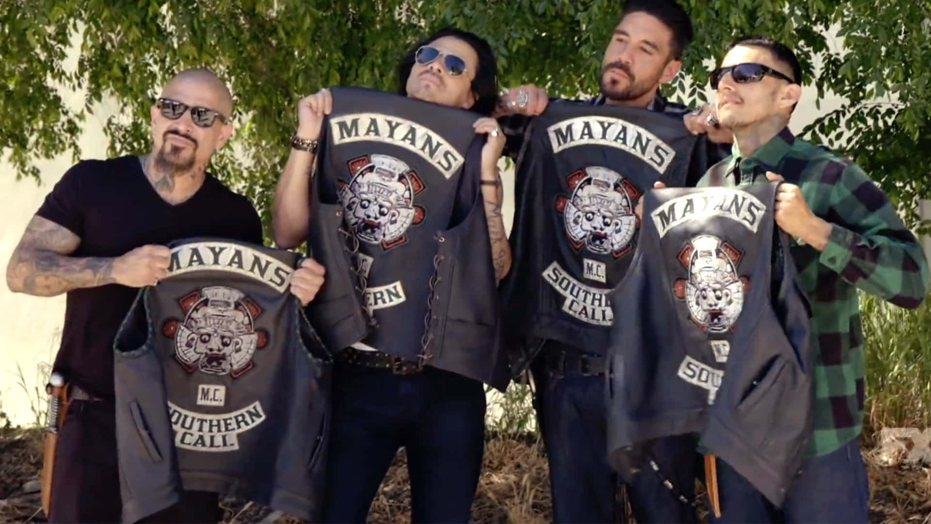 A Group Of Men Holding Up Shirts With A Motorcycle On Them Background