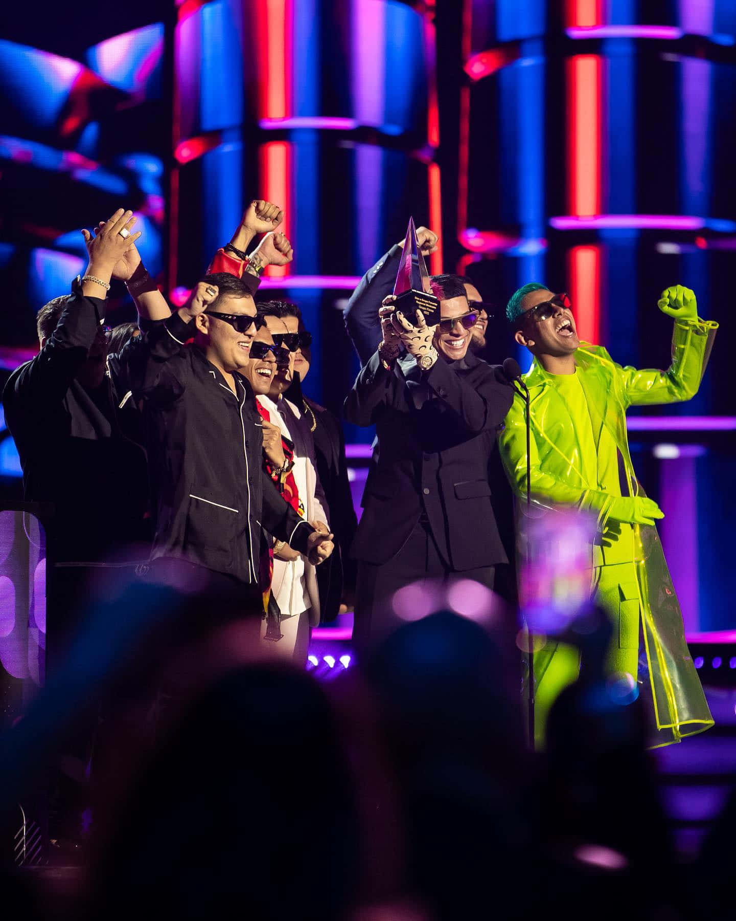 A Group Of Men In Suits On Stage Background