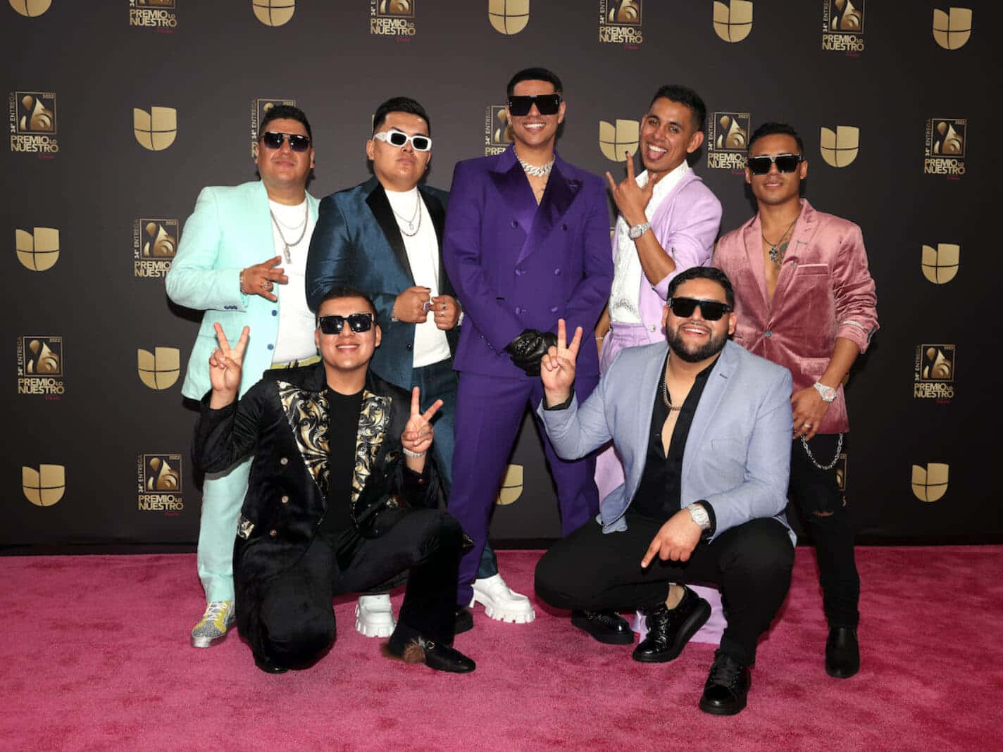 A Group Of Men In Suits Posing For A Photo On The Red Carpet Background
