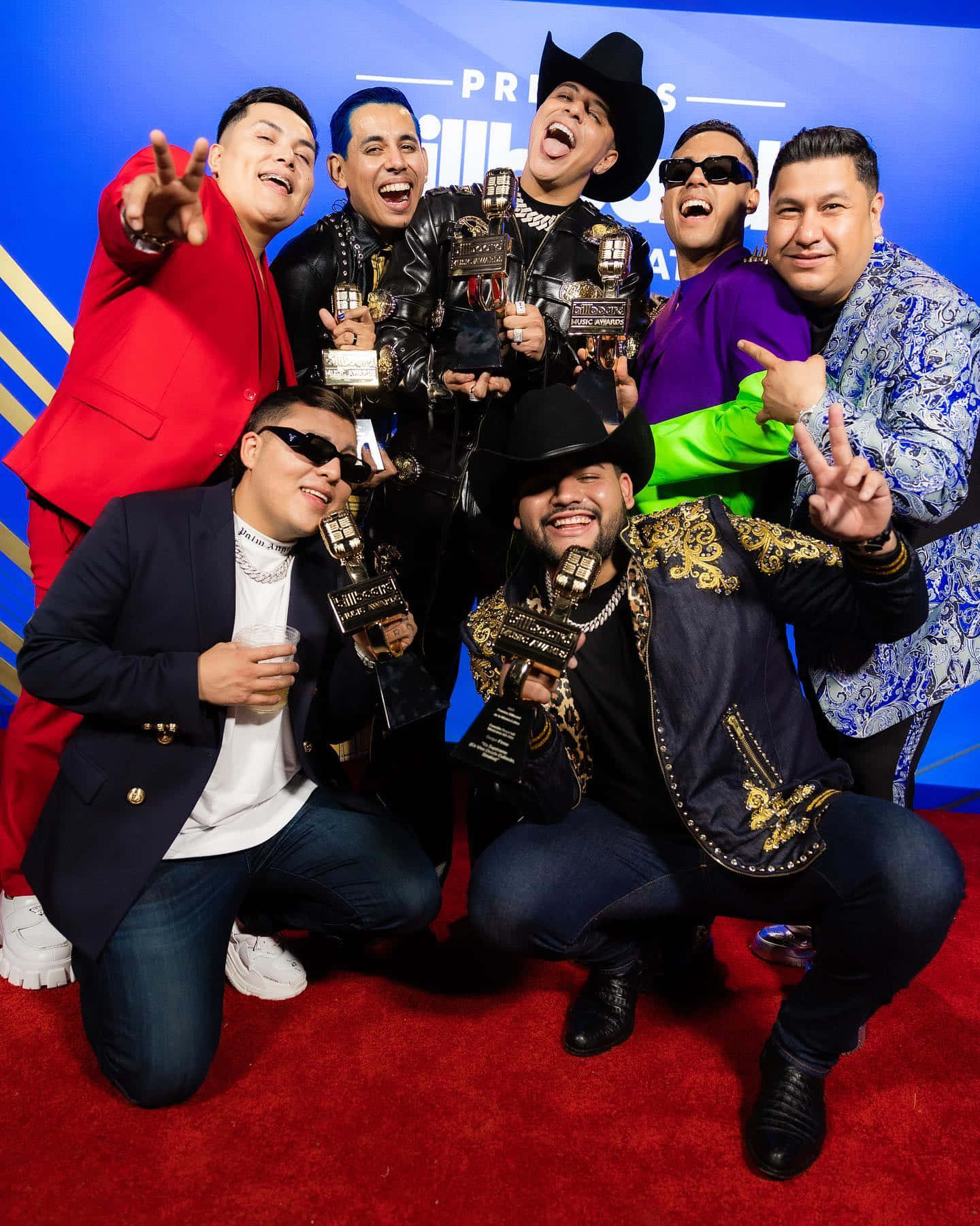 A Group Of Men Posing For A Photo On The Red Carpet Background