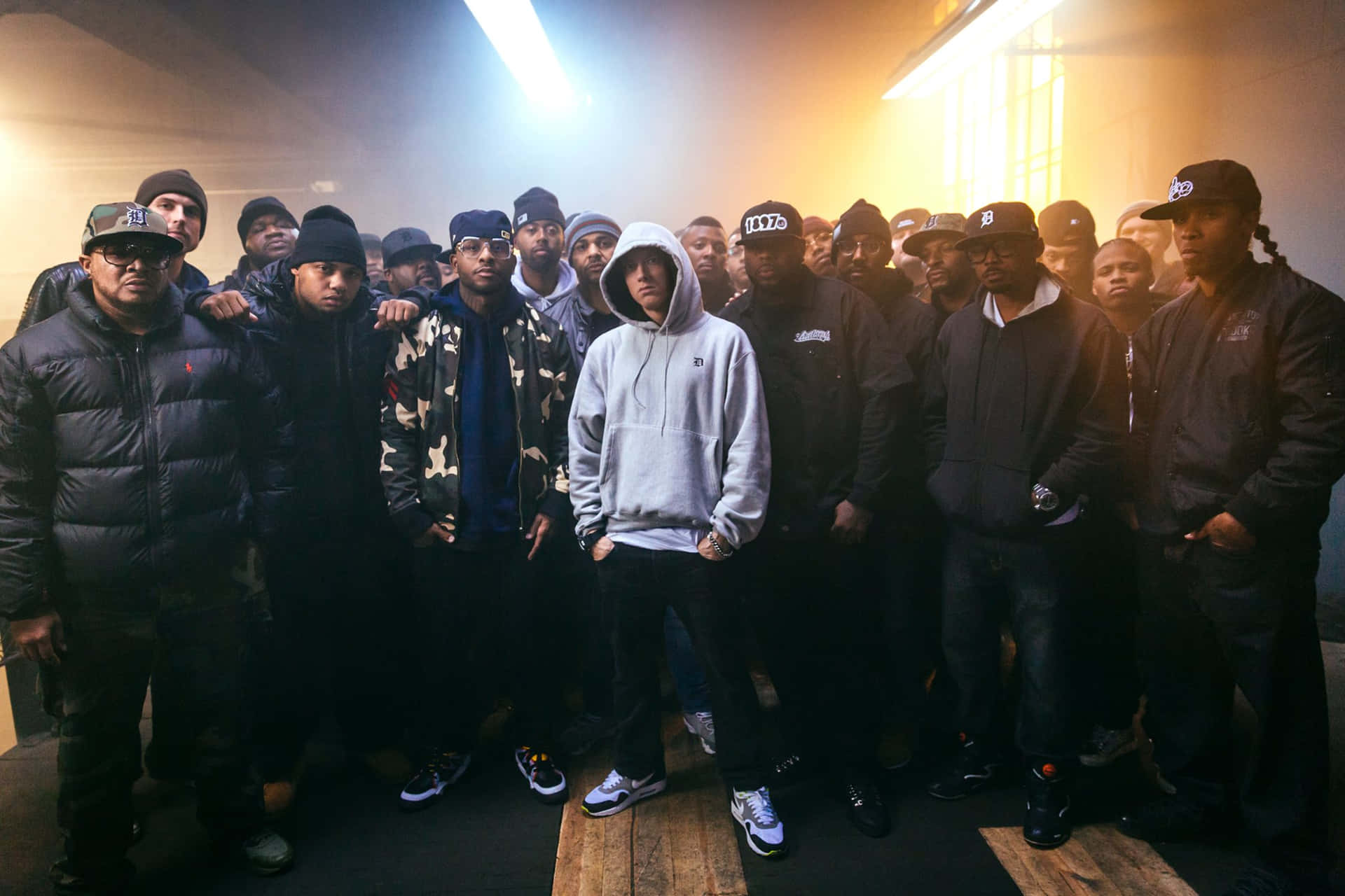 A Group Of Men Standing In Front Of A Light Background