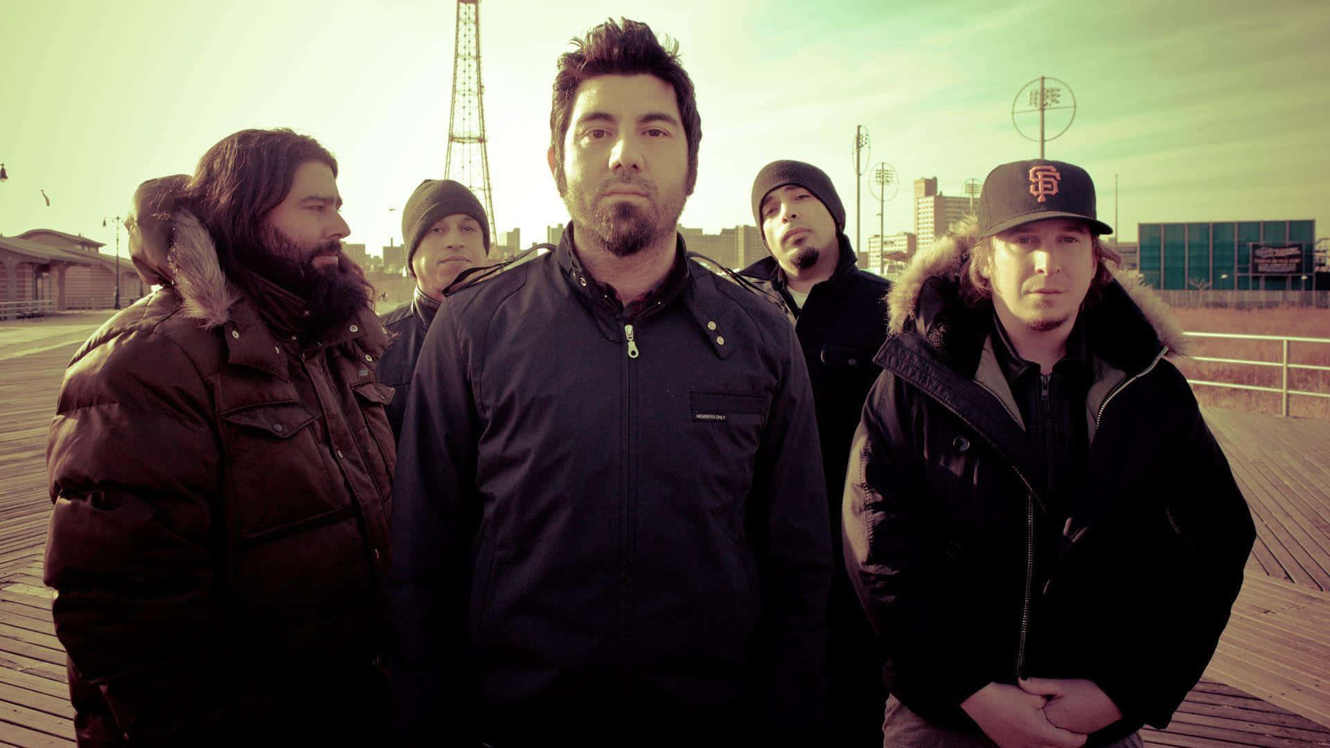 A Group Of Men Standing On A Boardwalk Background